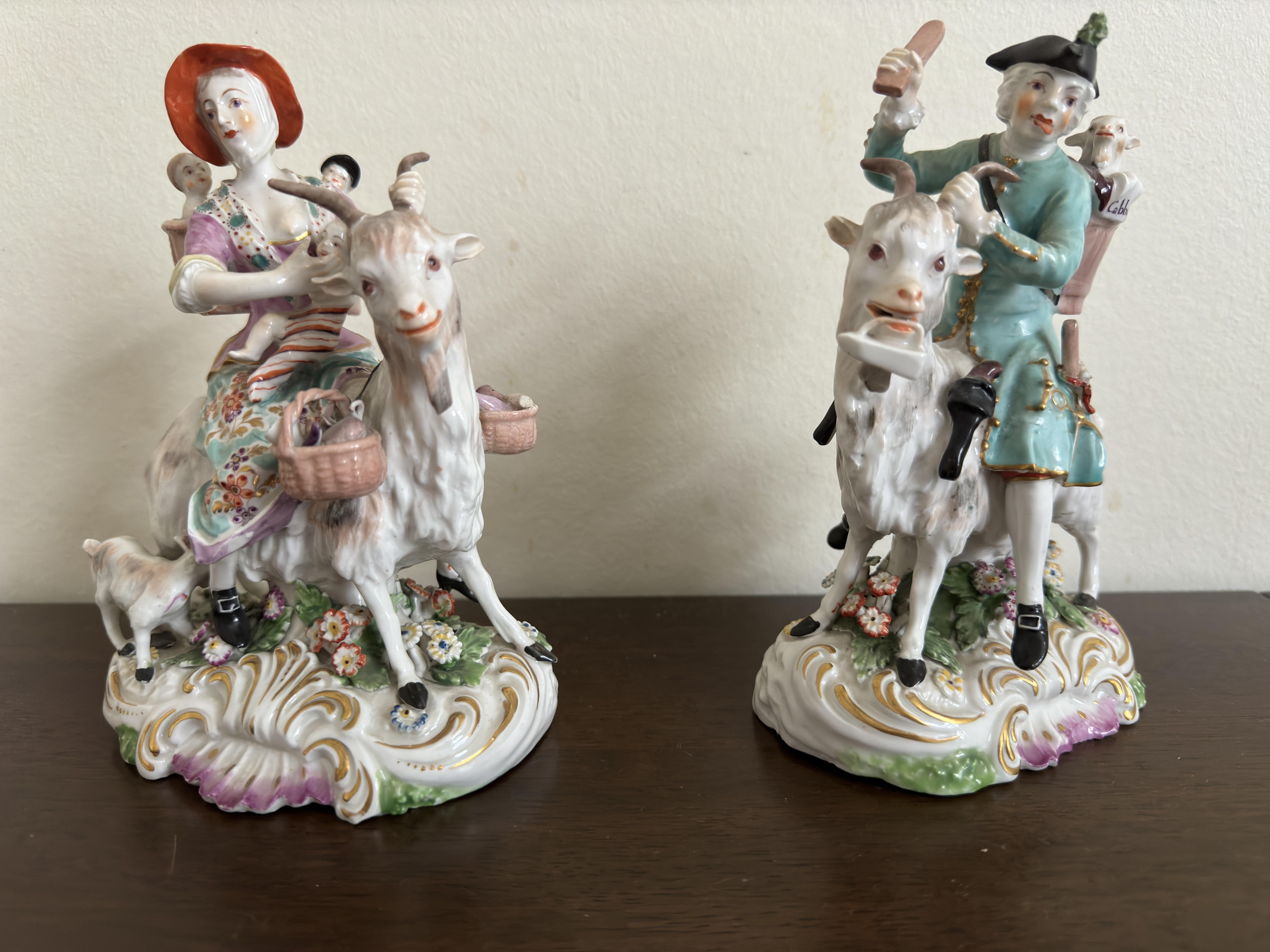 Pair of Derby Figures  depicting 'Welch Tailor and his Wife on Goats' circa 1800. 
These Derby figures were originally copied from the Meissen originals ( sculptor J J Kaendler). 
They have lovely detail from the little children and kids in the