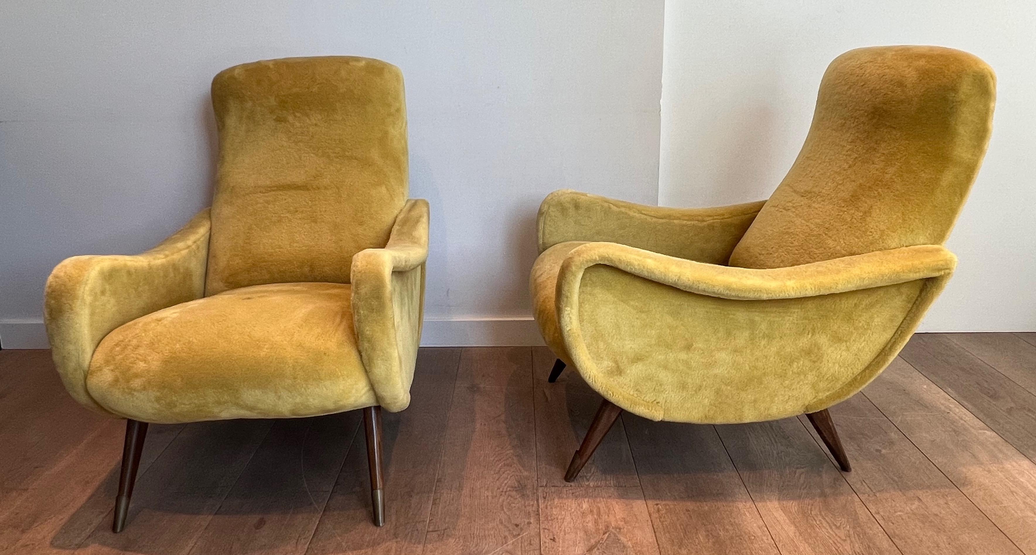 This very nice and iconic pair of design armchairs is made of a yellow velvet and wooden compass base decorated with a brass plaque on the front legs. This is an Italian work by famous designer Marco Zanusso. Circa 1960.