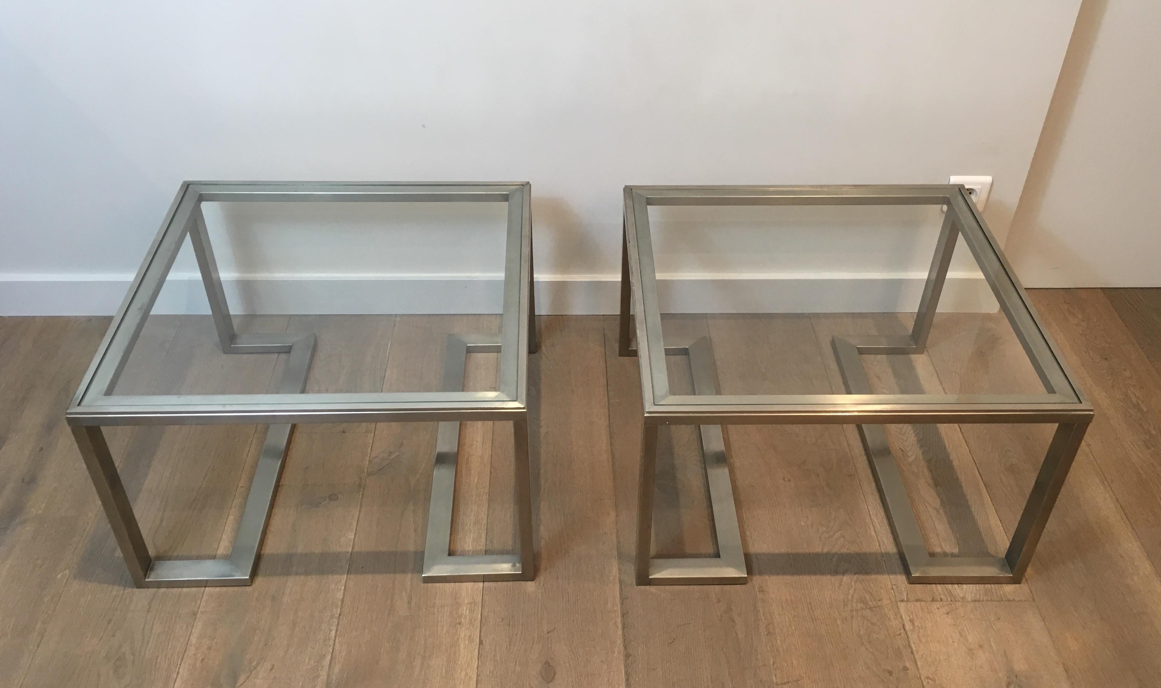This pair of side tables is made of brushed steel with glass shelves. The quality is very good and the design very nice, in the style of famous French designer Guy Lefèvre, circa 1970.