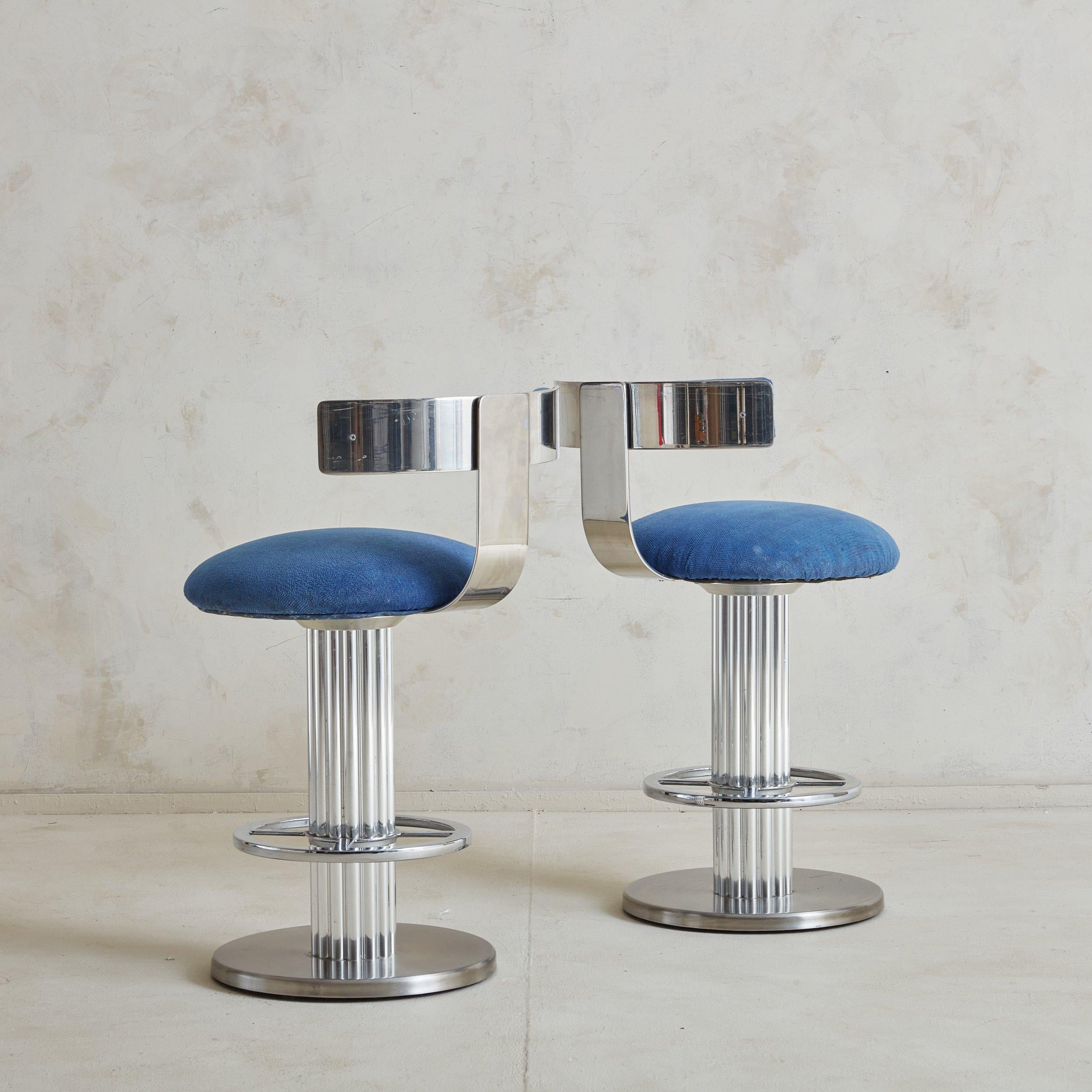 A pair of Design for Leisure stools with their easily recognizable fluted chromed nickel base. This pair has a curved back rest; swivel feature and foot rest. 
 DIMENSIONS: 18ʺW x 22ʺD × 33ʺH; 25”Seat Height