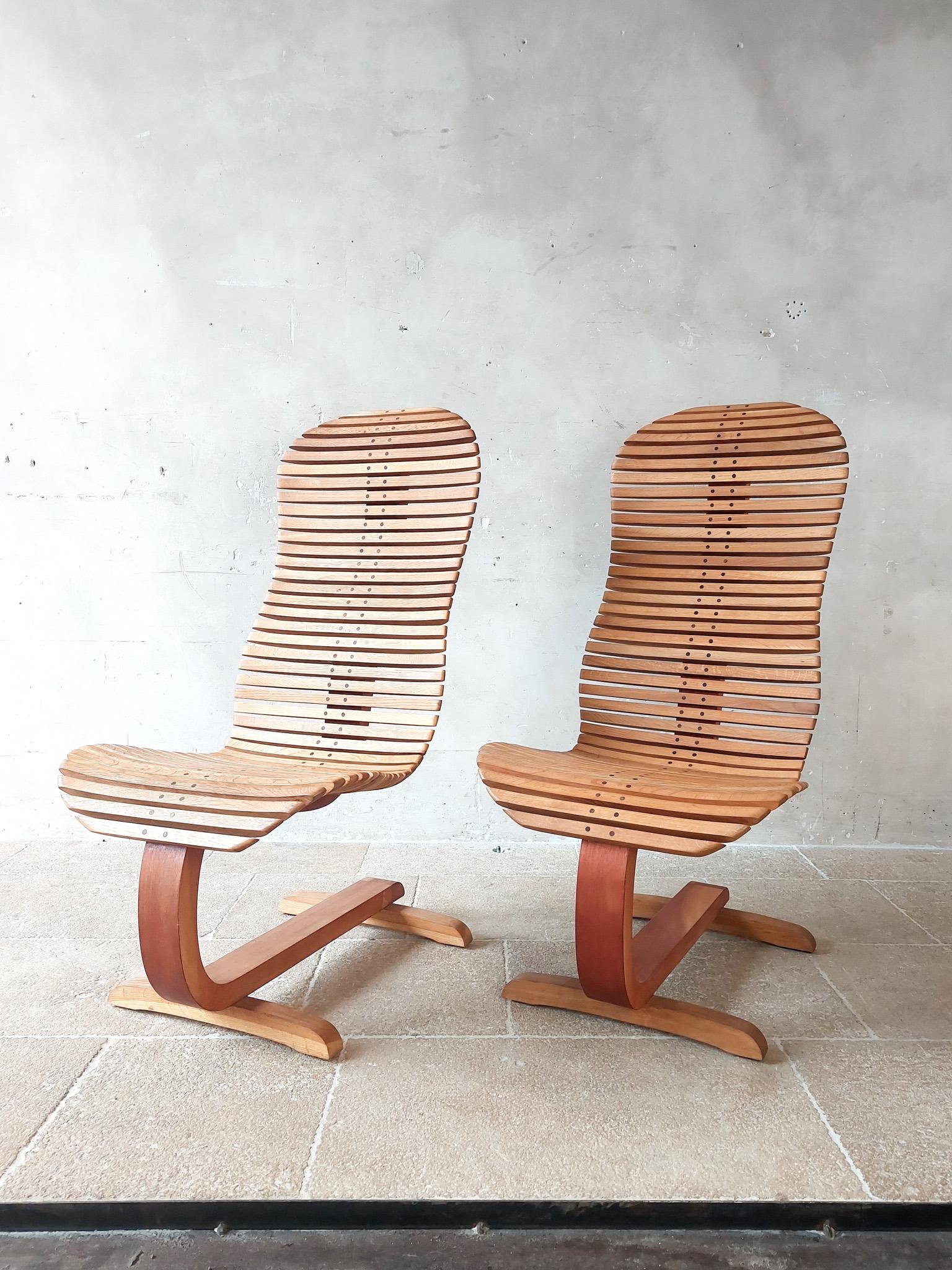 A pair of designer wooden lounge chairs, crafted with precision and style. Originating from Greece, these chairs are constructed from oak and Sungkai wood, showcasing their natural beauty and durability.

With their captivating organic shapes, these