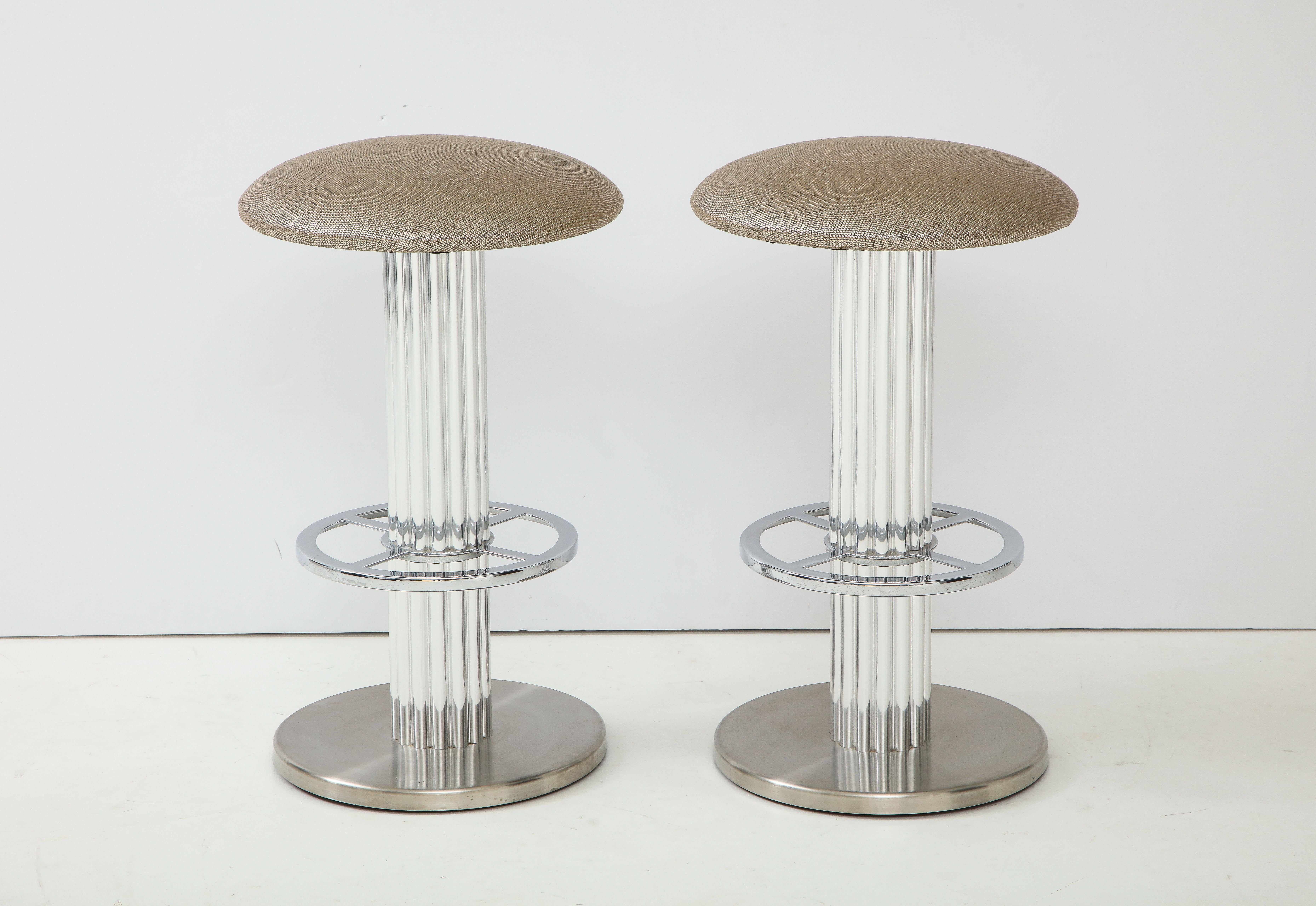 Pair of bar stools in polished and brushed chrome over steel frames.
The seats have been newly reupholstered in a luxurious ROMO metallic fabric.