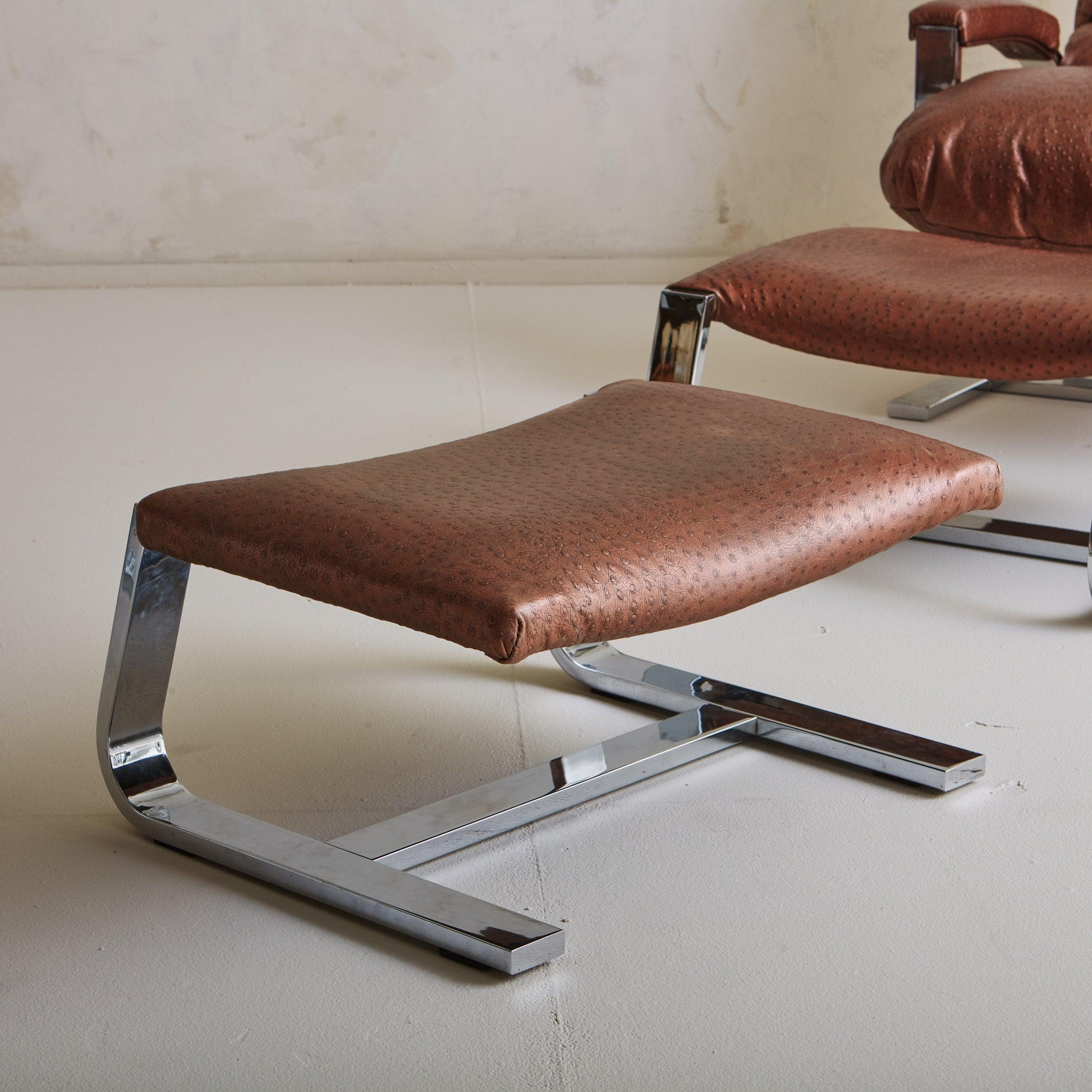 A pair of Design Institute of America lounge chairs upholstered in a beautiful textured Robert Allen Gilded Dubaku copper leather. These chairs have cantilevered polished chrome bases and upholstered arms. They retain a matching ottoman. 20th