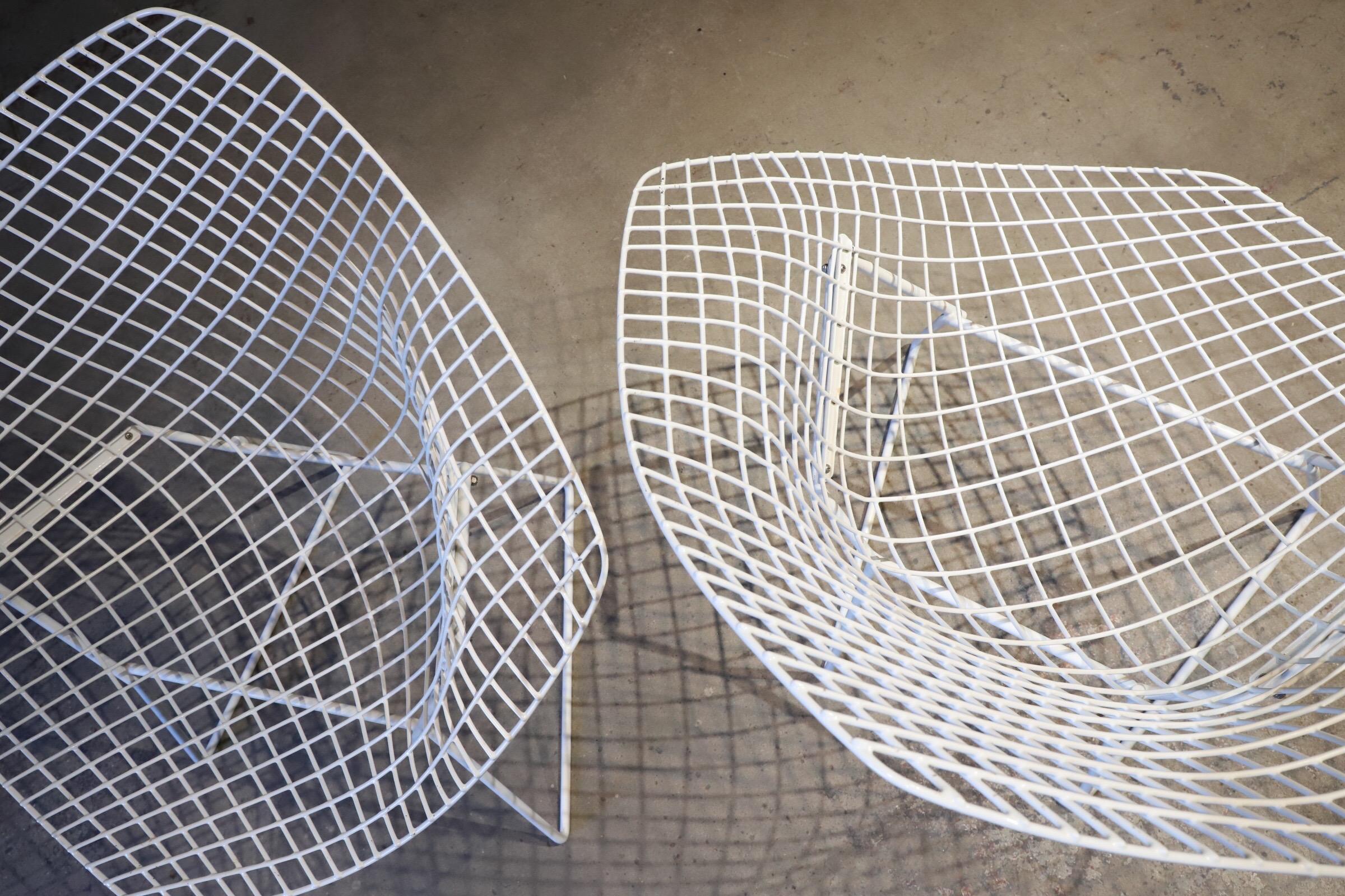 Pair of white diamond chairs by Harry Bertoia for Knoll. Original condition. Diamonds are timeless & always collectible. Photographed with Saarinen tulip stool for scale. Total of four chairs available (two shown in this listing).