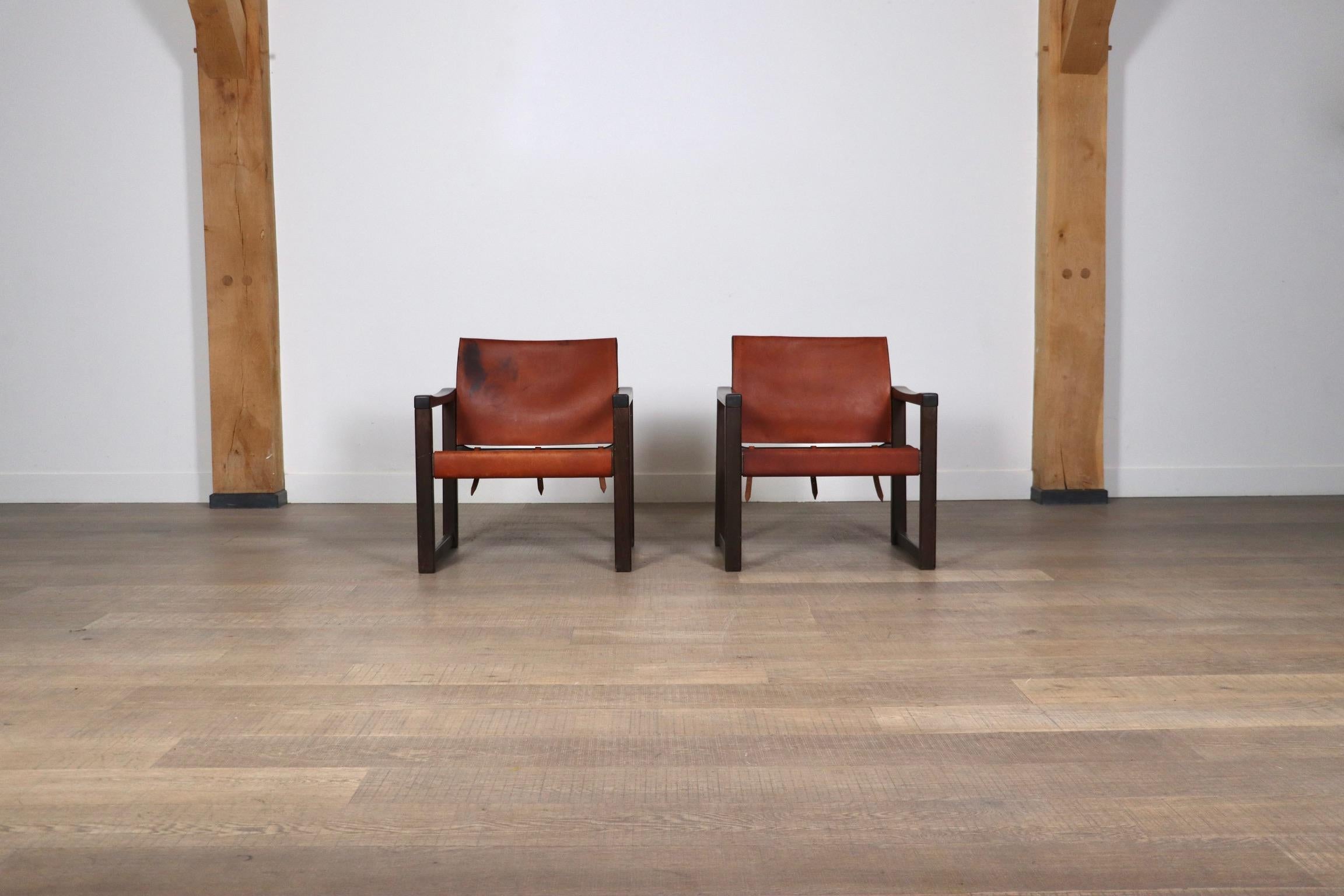 Nice pair of Safari lounge chairs model Diana designed by Karin Mobring for IKEA, Sweden 1970. These chairs have a solid stained pine wooden frame with original cognac saddle leather seating with very nice patina. The straps at the back give the