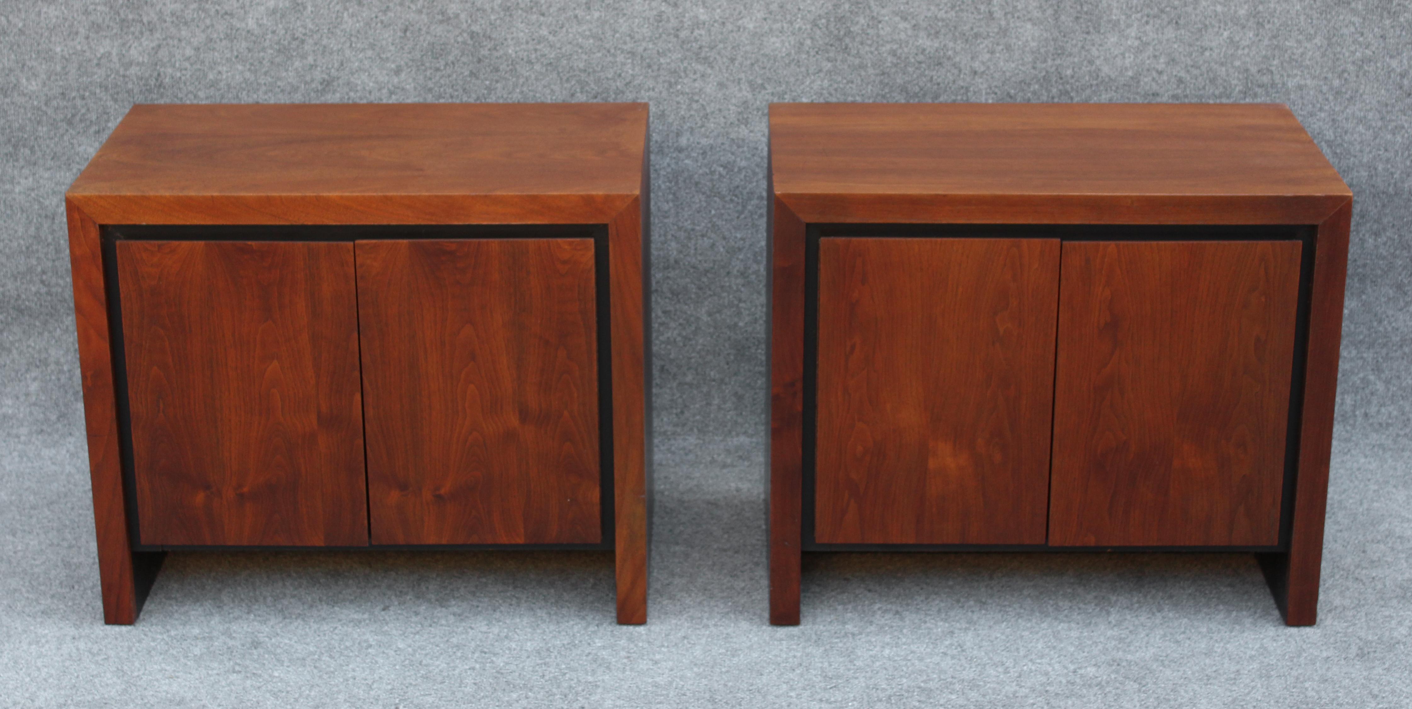 This pair of nightstands or end tables were made by Dillingham, known for their excellent craftsmanship and quality. Our pair features a classically mid-century walnut construction with handsome bookmatched doors. Their design is stoic and