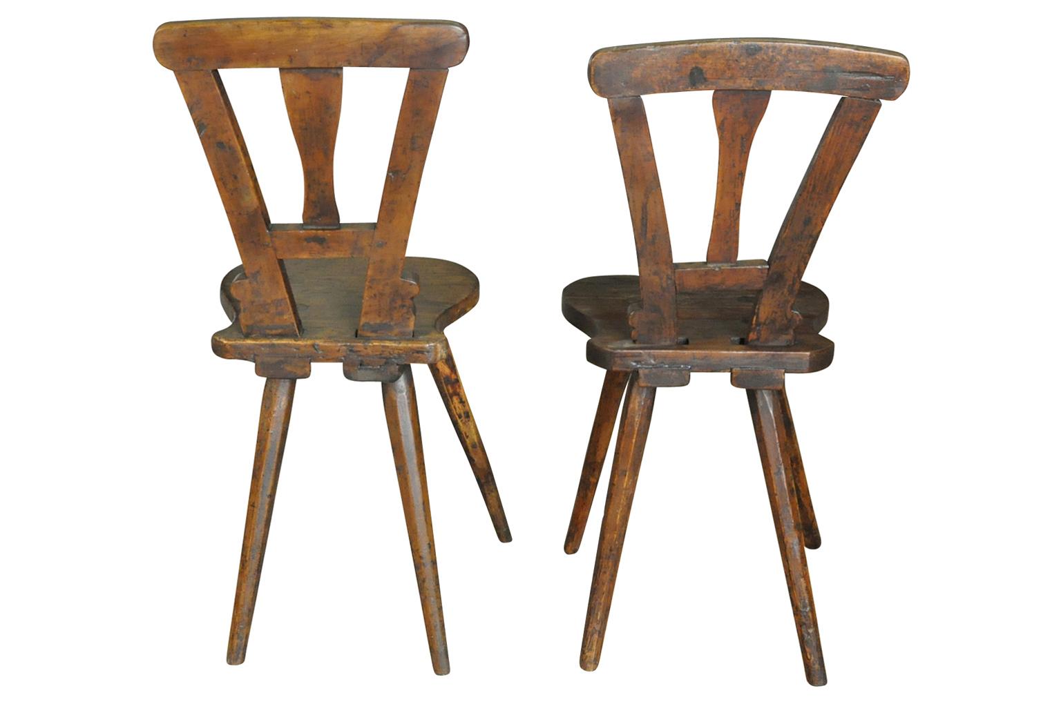A very charming pair of 19th century diminutive side chairs from the Alsace region of France. Wonderfully constructed from walnut. Very luminous patina. A terrific accent for any casual living area. The chairs vary slightly in dimension. One