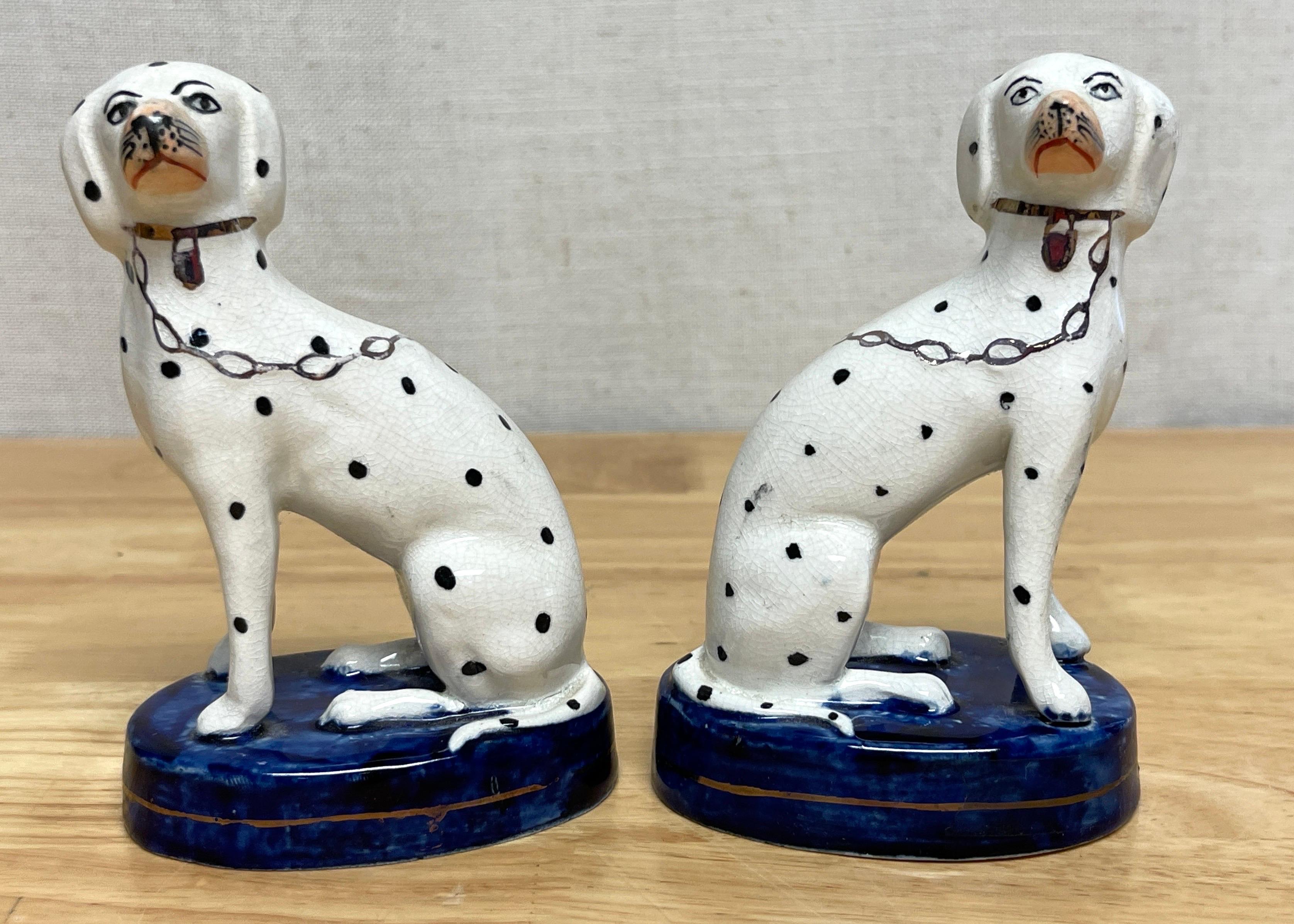 Pair of Diminutive Antique Staffordshire seated Dalmatians with chains 
England, Circa 1880s

A good pair of antique Staffordshire seated Dalmatians, Each one realistically modeled with separated front legs. Painted in black and white with luster
