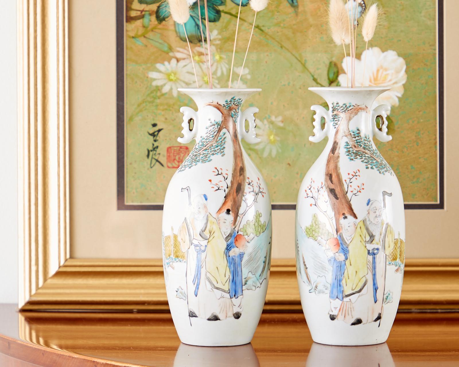 Remarkable pair of diminutive Chinese porcelain Fencai vases featuring beautifully decorated landscape scenes. Vibrant famille rose colors depict a scholar and his attendant offering him a peach with a pine tree and waterfall in the background. Each