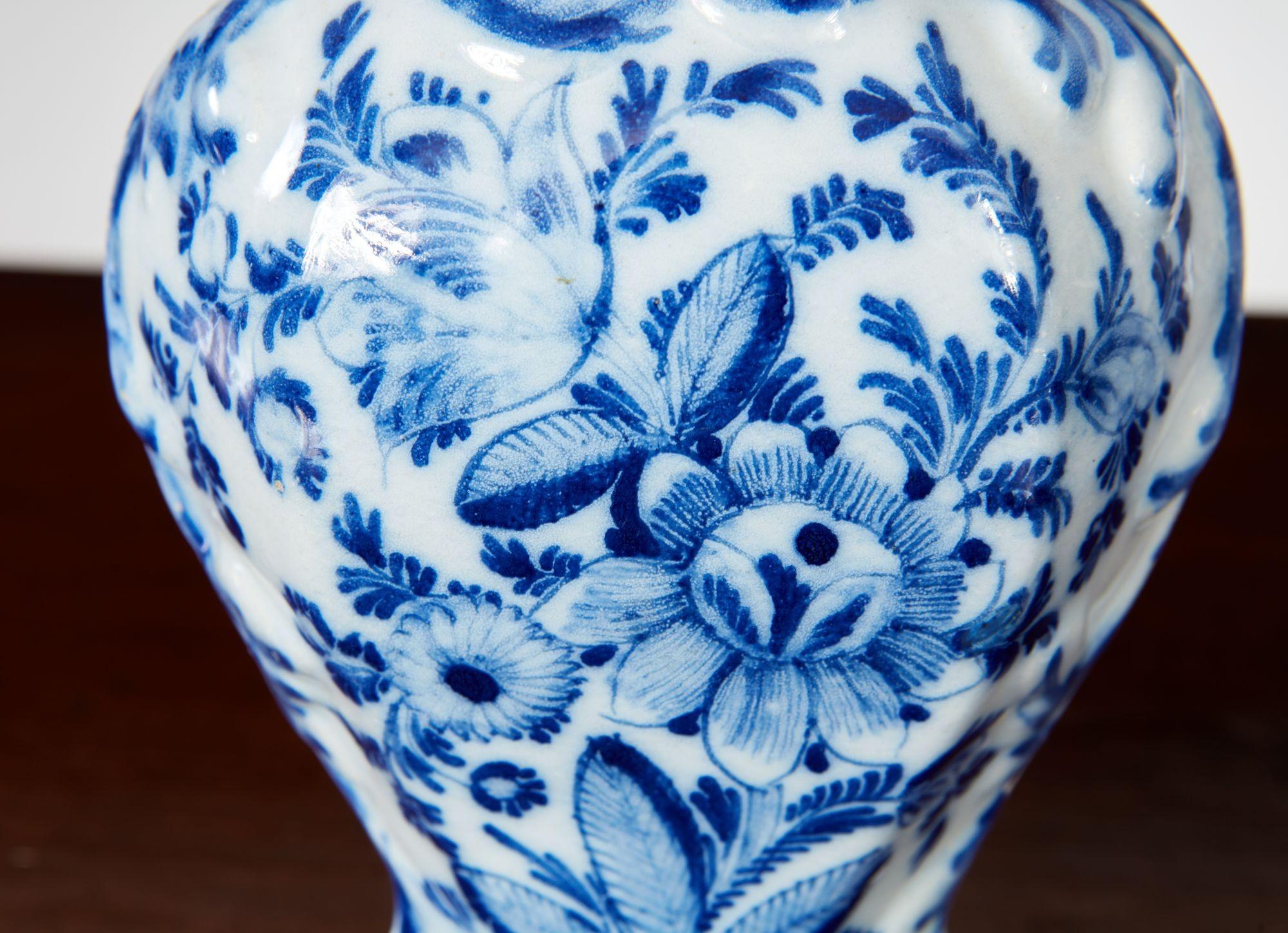 Una coppia di piccoli vasi delft con decorazioni floreali e fogliate dipinte a mano in blu su fondo bianco su corpi sagomati con colletti superiori esagonali sopra spalle più grandi che si assottigliano a basi esagonali. Inglese, 18° secolo.