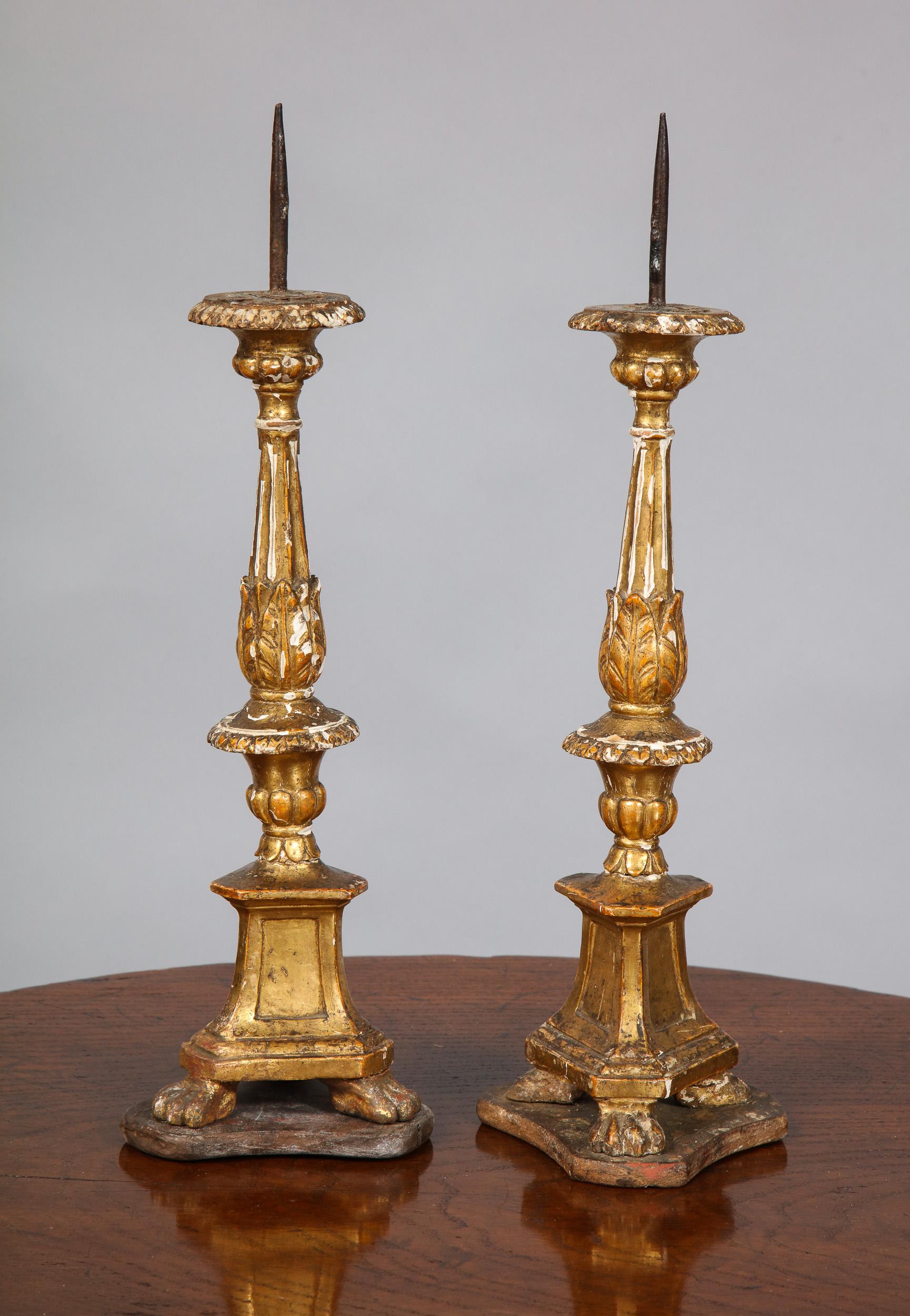 Fine pair of 18th century Italian giltwood pricket candlesticks with original water gilt decoration having foliate carving, fluted shafts and standing on platformed paw feet, in 