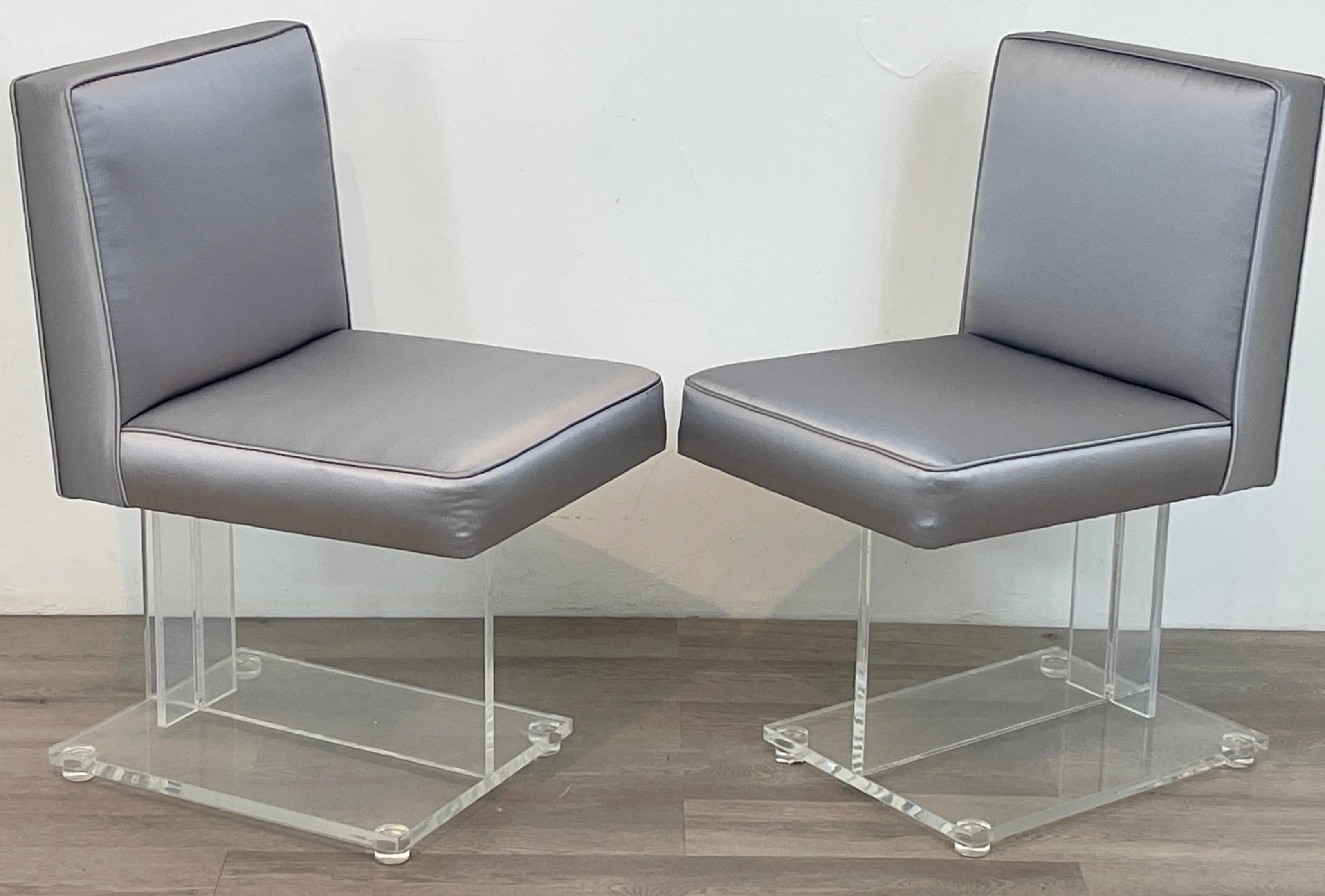 Pair of 1970s Diminutive Sculptural Lucite Chairs 
Each one with gray upholstered back and seat rest, on a sculptural lucite base. 
The design displays influences of  works by Vladimir Kagan. 
Would make great boudoir/slipper chairs. 
Each chair