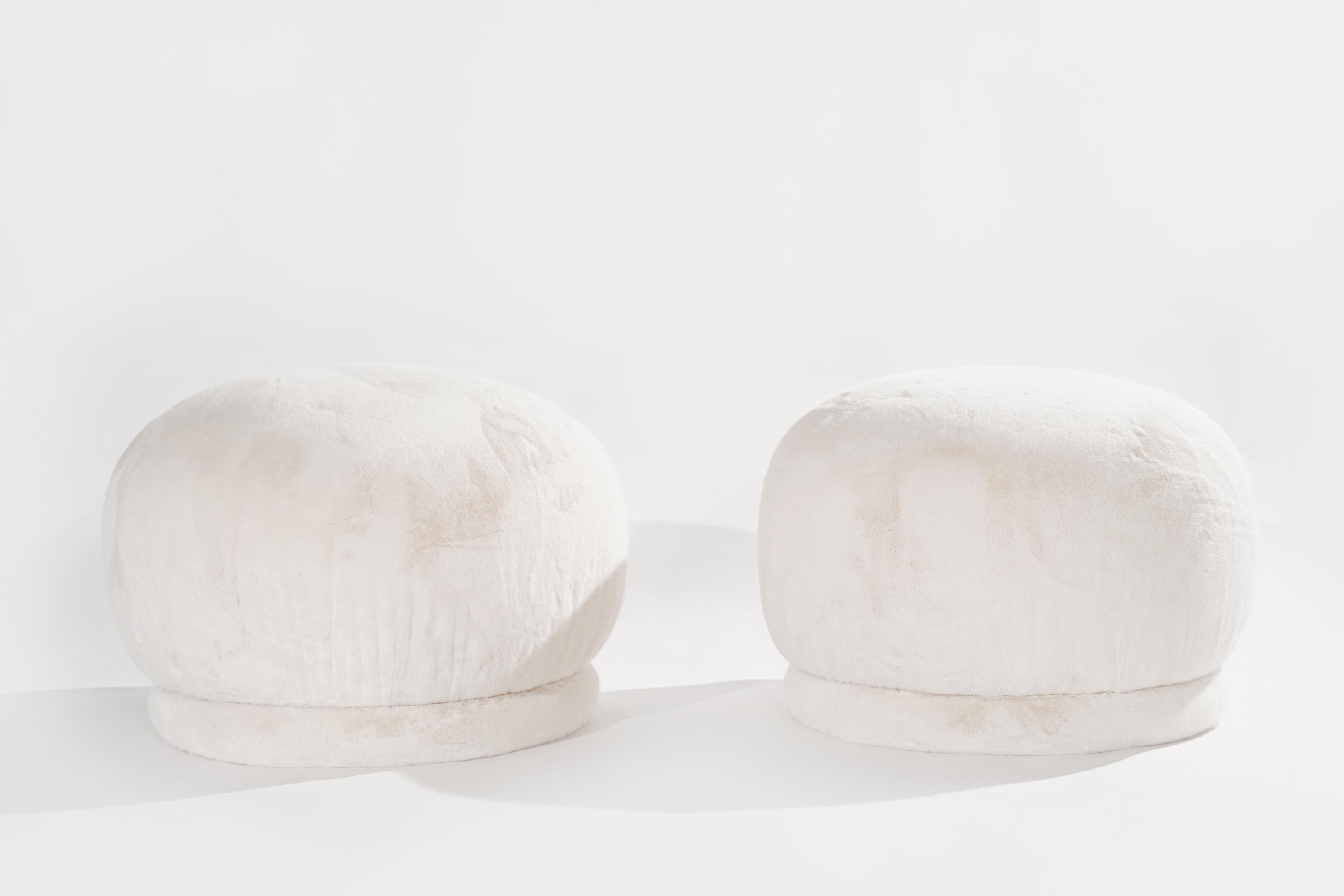 Timelessly and organic set of poufs ottomans by Directional professionally reupholstered in high-end soft faux fur. Plush and comfortable, the poufs feature a rarely seen swivel mechanism and are versatile enough to be easily incorporated as benches