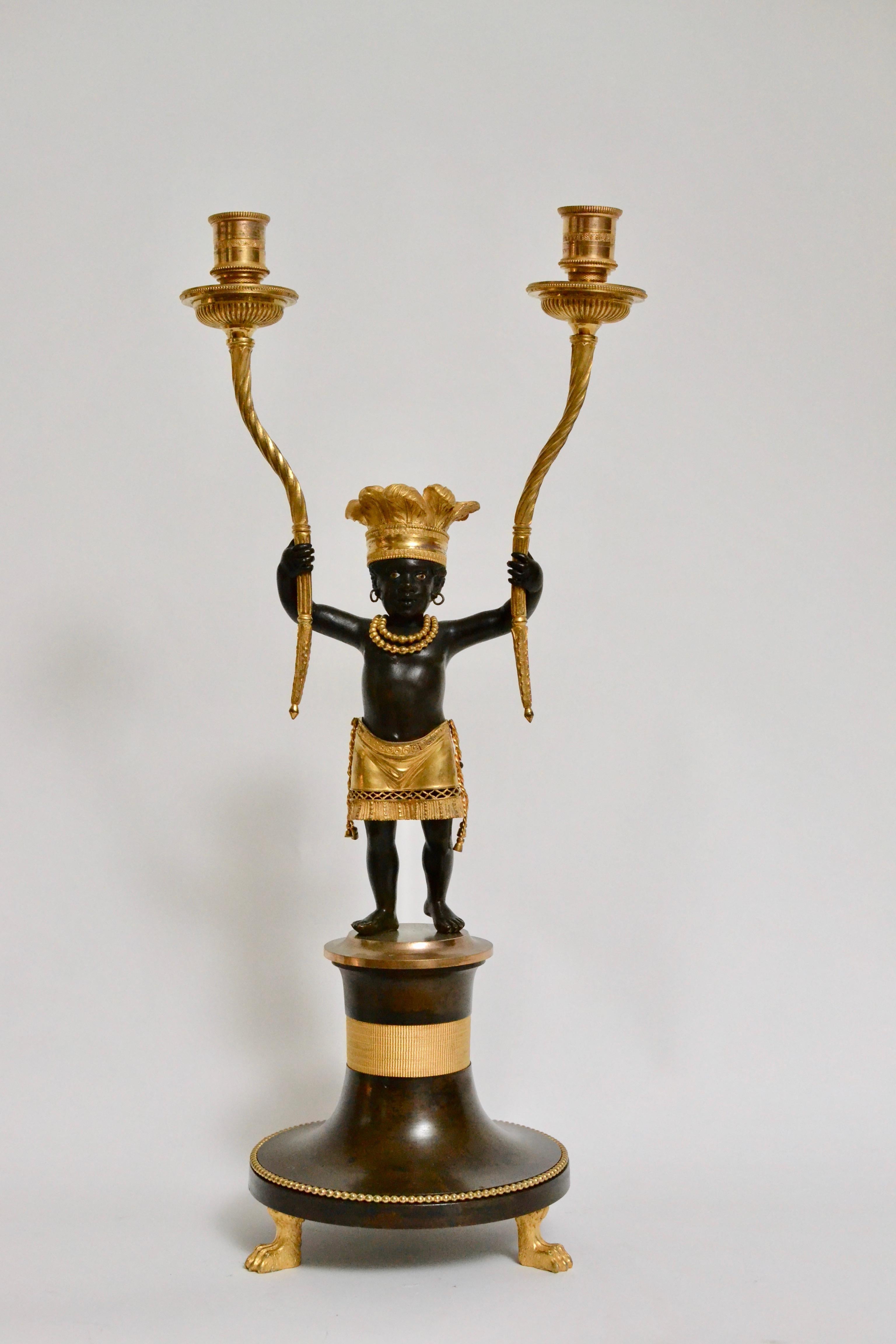 A very rare pair of Directoire à L’Amérique or à l'Indien ormolu and patinated bronze candelabra after a design, circa 1799 by Jean-Simon Deverberie (1764-1824). An Identical pair is in the Museum François Duesberg. The bronze figures with enameled
