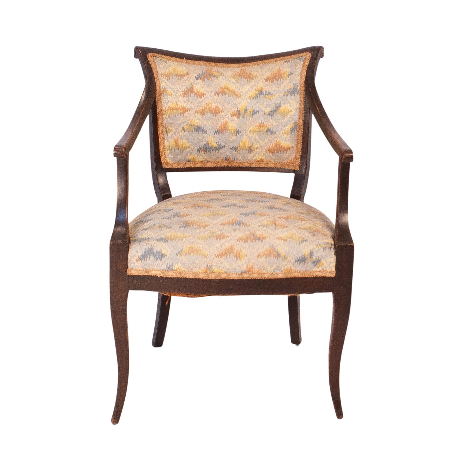 A pair of graceful and unique Italian Directoire armchairs circa 1820 made of walnut with old upholstery. This kind of chair is seen all over Europe early in the 19th century. The Italians added more curves and detail that make the chairs