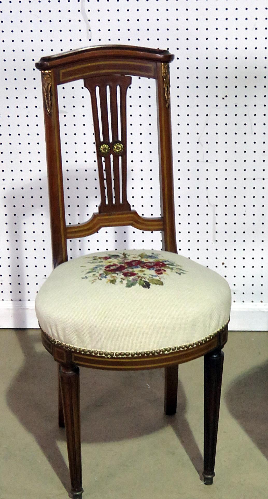 Pair of Directoire style slipper chairs with needle point upholstery, gilt highlights, and nailhead trim.