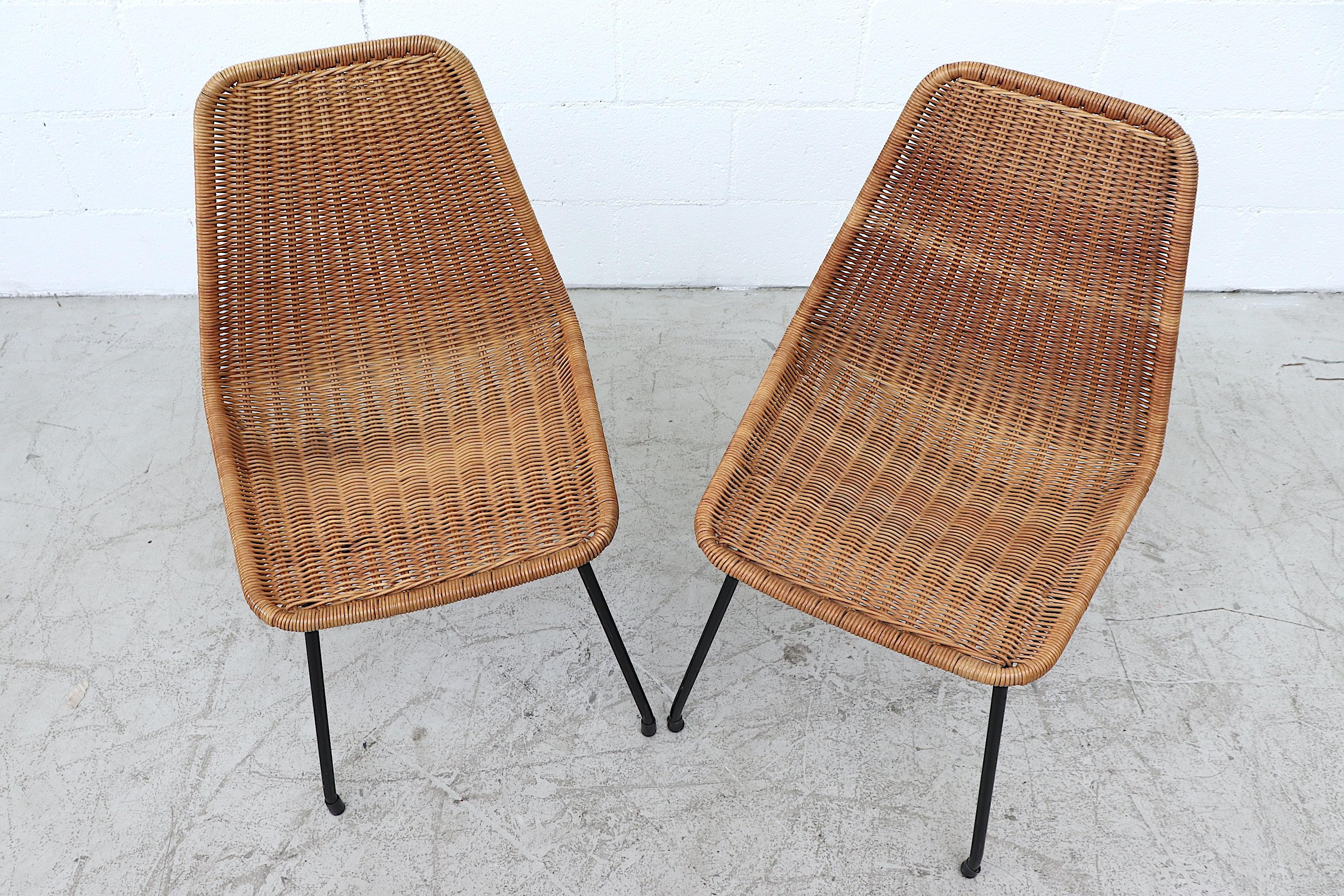 Handsome pair of Dirk van Sliedregt style rattan shell seat chair with black enameled metal frame. In original condition with minimal rattan loss and moderate signs of wear consistent with age and use. Set price.