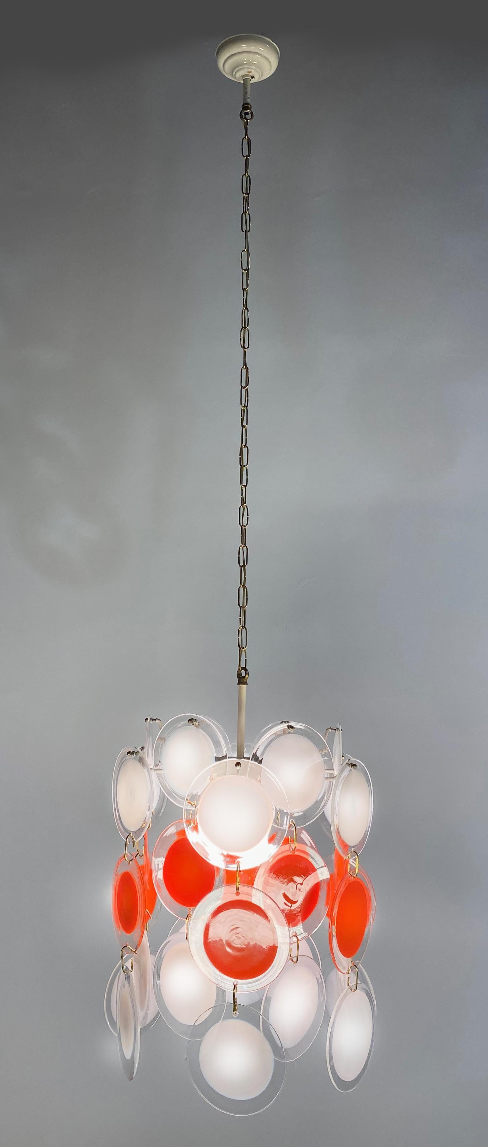 Spectacular pair of chandeliers by Vistosi made in Murano. Each chandelier is formed by 36 discs of precious Murano glass are arranged on three levels. Nine-light. Measures: Height without chain 70 cm.
   