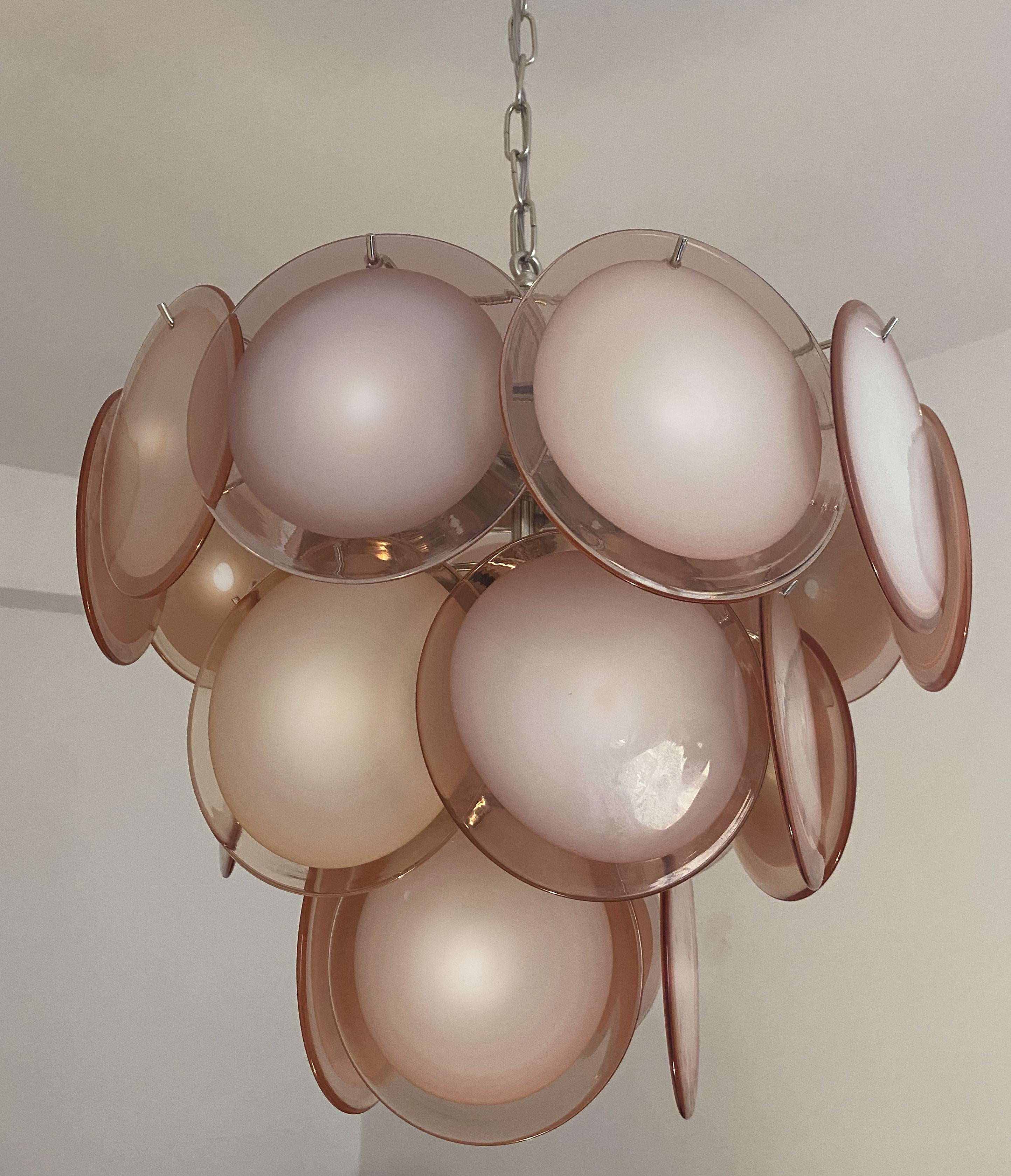 Spectacular pair of chandeliers by Vistosi made in Murano. Each chandelier is formed by 23 antique pink discs of precious Murano glass are arranged on three levels. Seven-light. Measures: Height without chain 00 cm. Available also with white