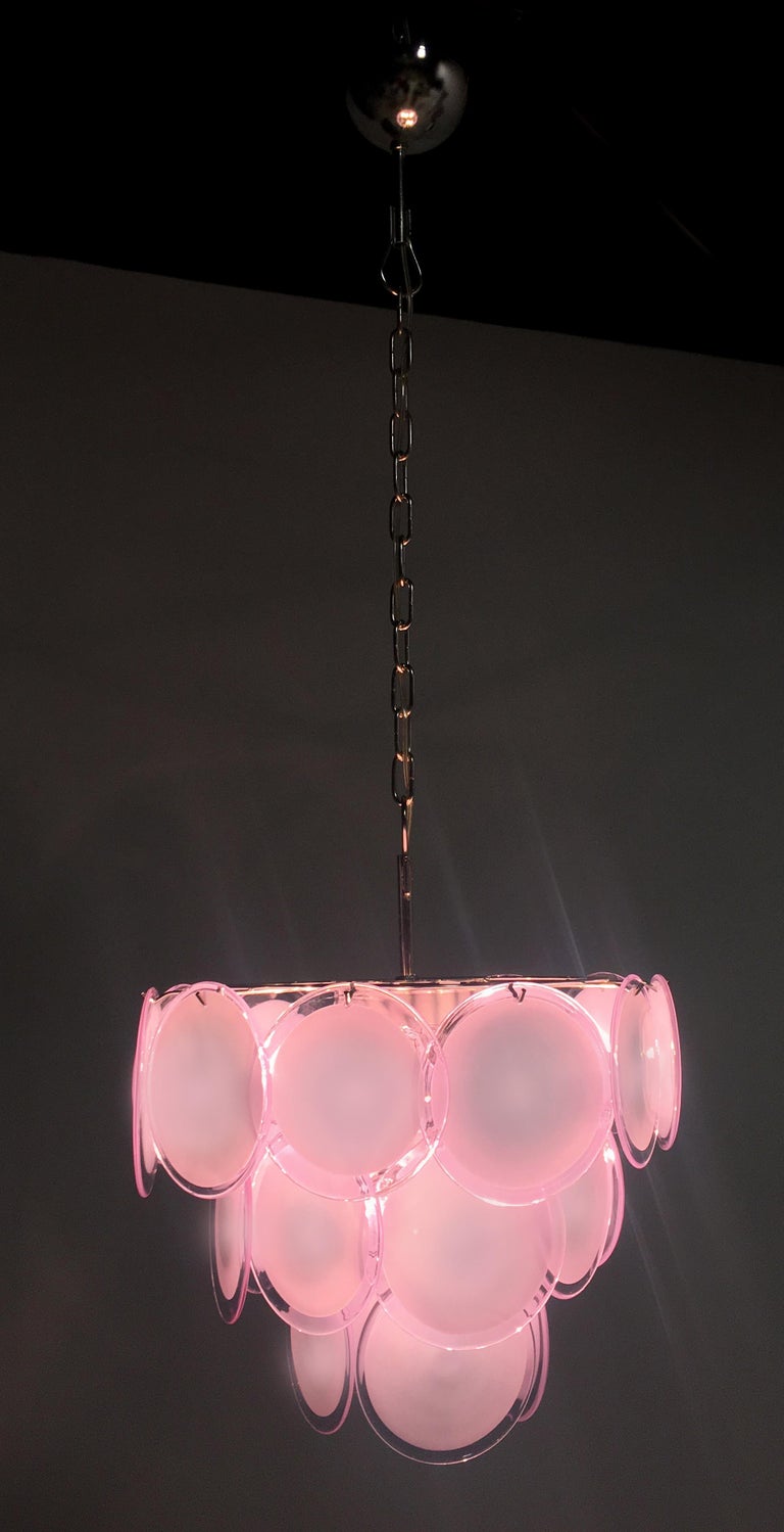 Vistosi midcentury pink discs Murano glass Italian chandeliers.

Spectacular pair chandeliers by Vistosi made in Murano formed by 23 pink discs of precious Murano glass are arranged on three levels. Seven lights. Measures: Height without chain 50