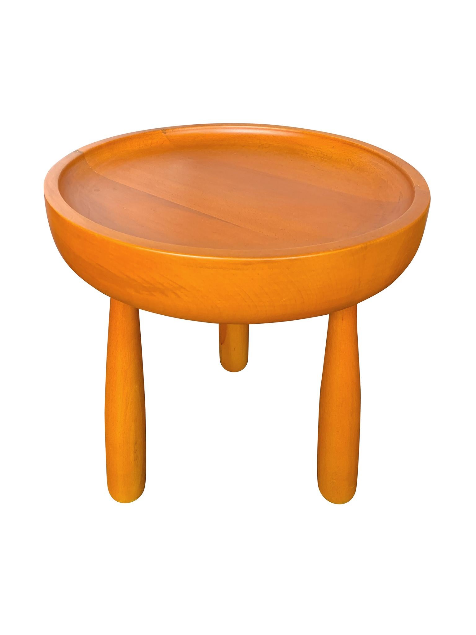 Pair of 20th century round stool side tables. Designed in the style of Sergio Rodrigues, they have dish tops and three legs that taper upward. The wood is a beautiful, warm orange-yellow tone.

Dimensions:
15 in. diameter
17 in.