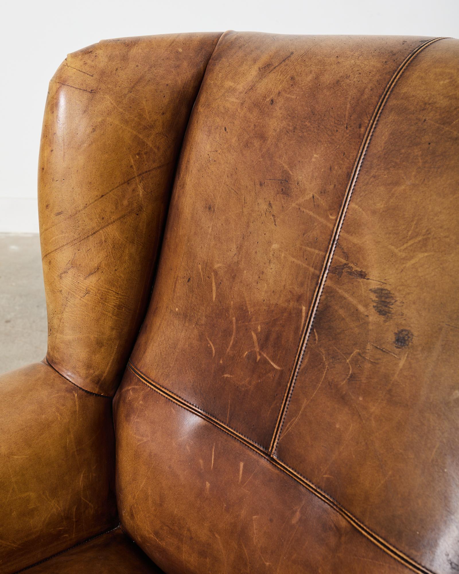 Contemporary Pair of Distressed Cigar Leather Wingback Chairs with Ottomans