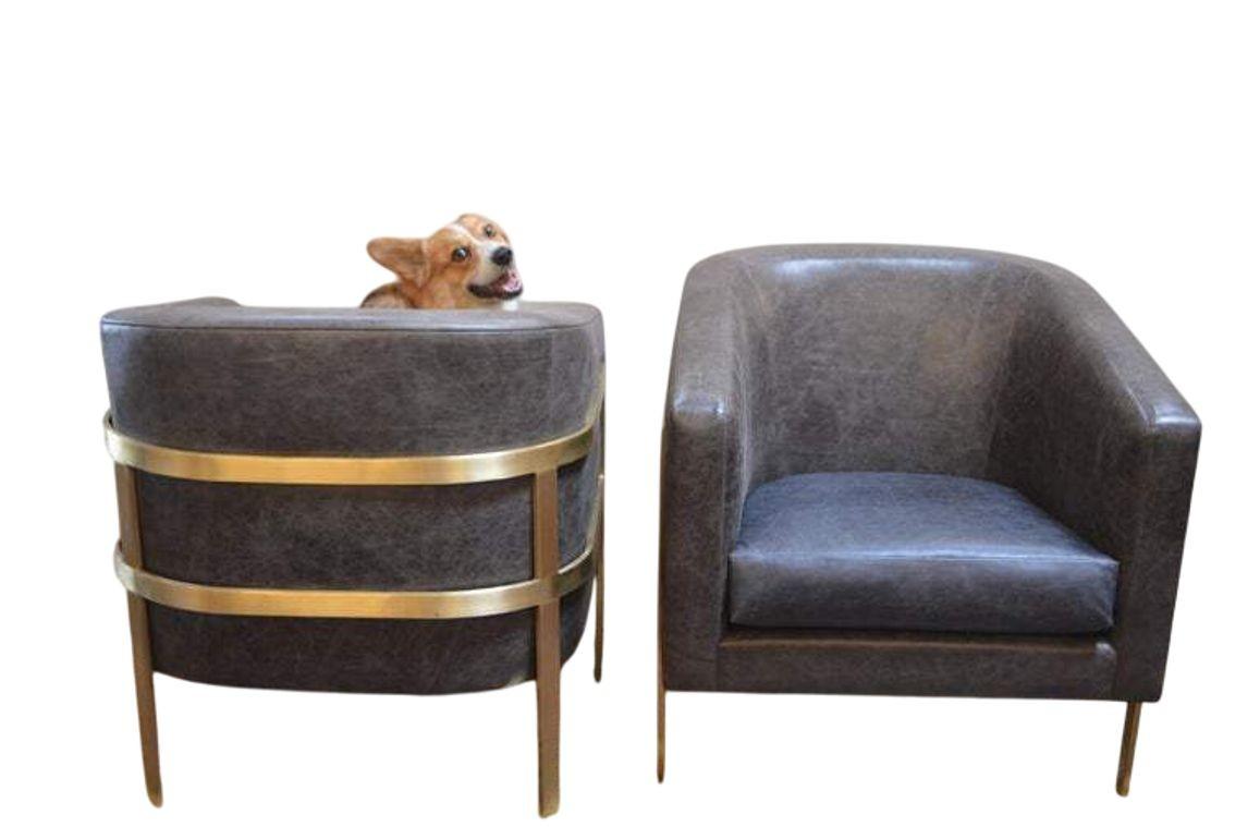 Striking pair of modernist armchairs from the 1970's featuring a polished brass frame paired with distressed grey leather backs and arms, complemented by deep navy-blue leather seat cushions. The design recalls the sleek, geometric lines associated
