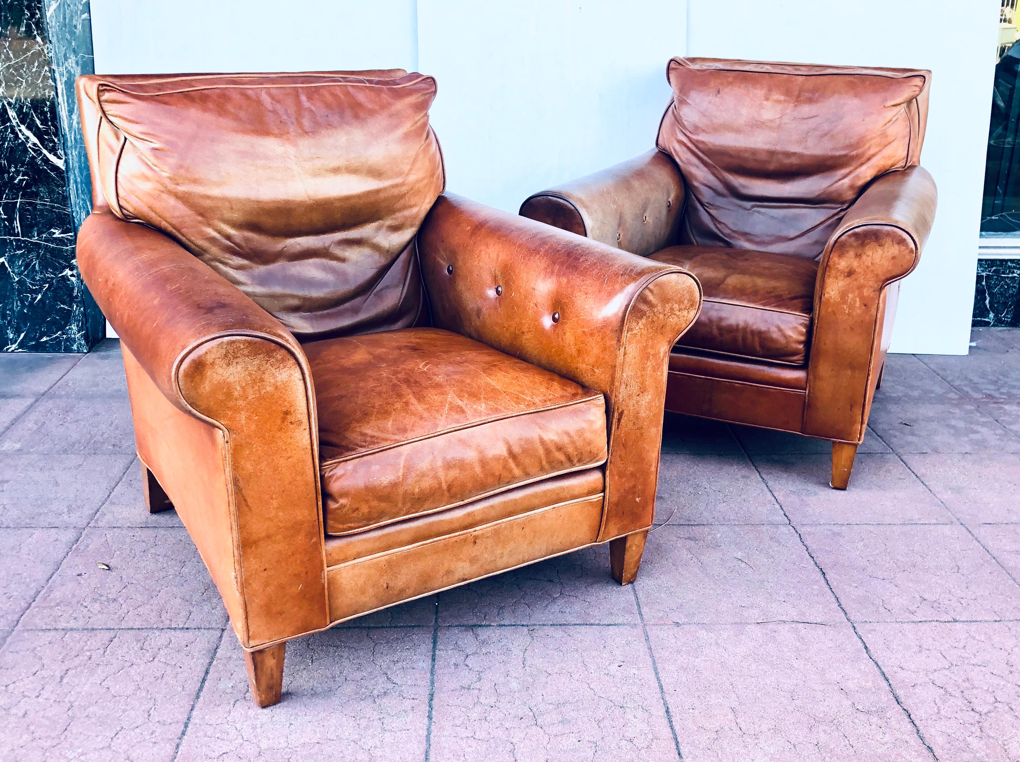A classic pair of distressed leather club chairs by renowned furniture maker Ralph Lauren. Great traditional look! With solid wood legs . Sold As/Is please note one of the chairs has 3 side scratches as shown. Nicely worn leather. Very comfy.