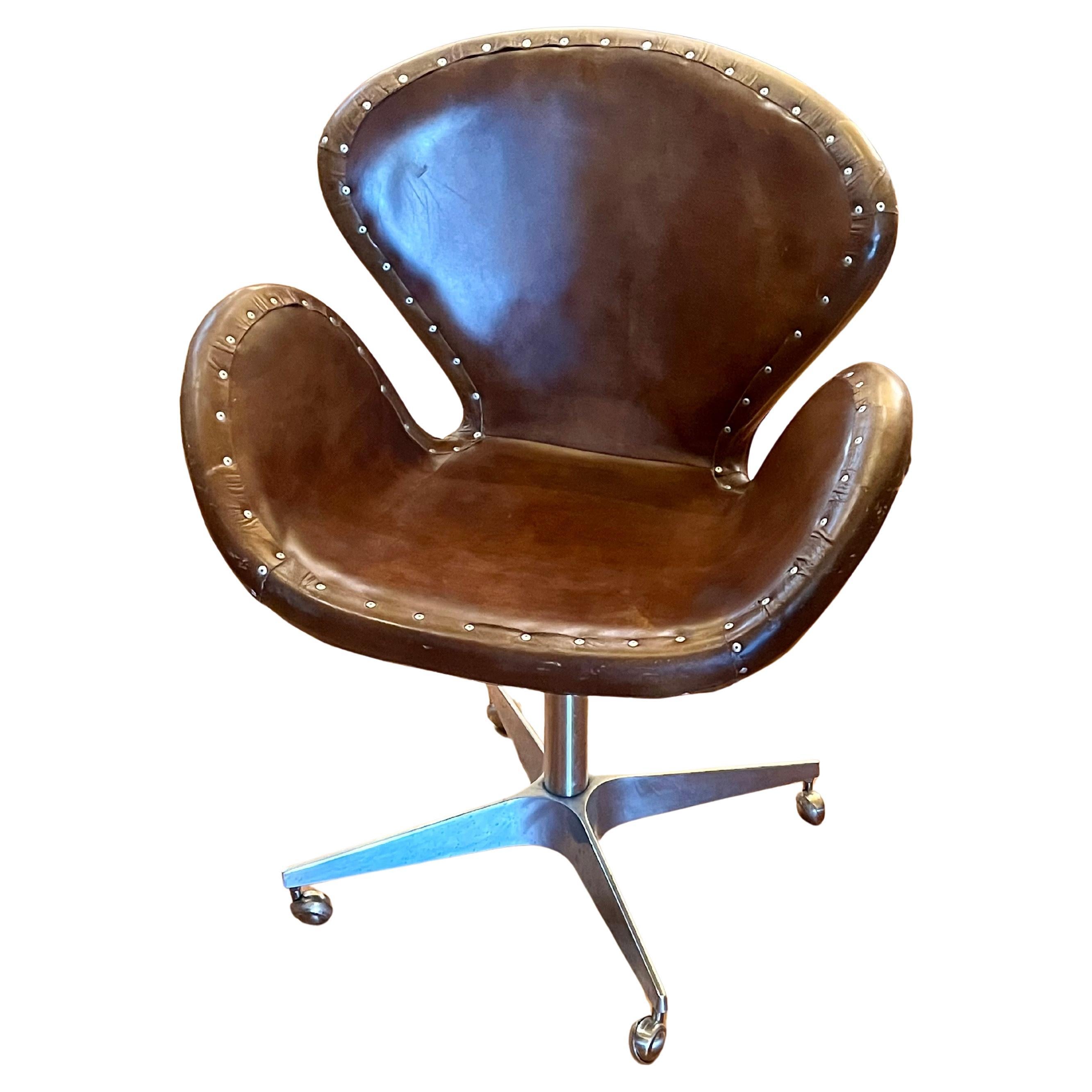 Nice pair of contemporary distressed leather swivel base chairs in the style of Arne Jacobsen, by Restoration Hardware very nice condition and great look good quality. Aviator style on casters very clean condition .