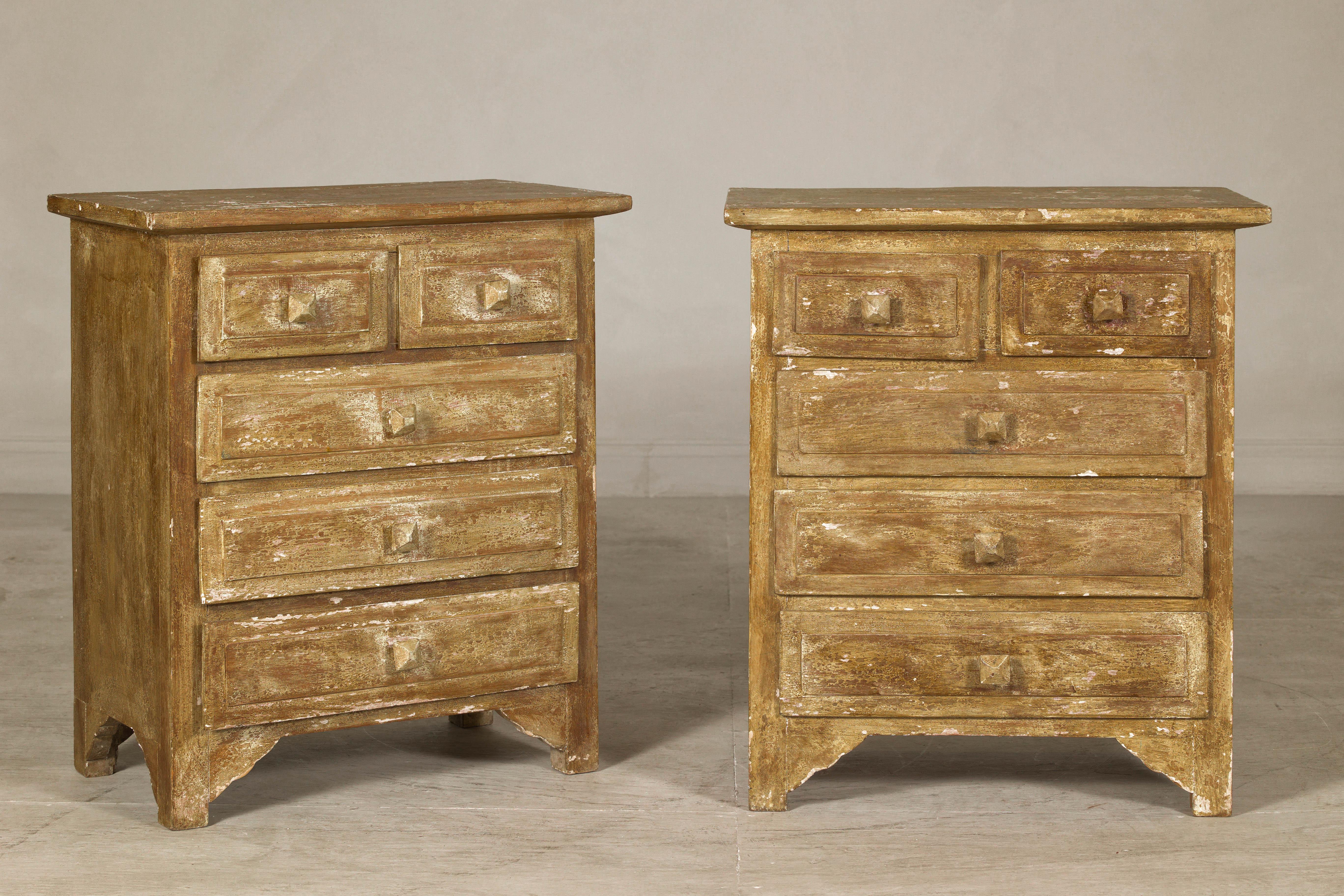 A near pair of vintage bedside chests with six drawers and distressed patina. A harmonious blend of rustic charm and practical design, this pair of vintage nightstands is a testament to timeless craftsmanship. Each piece features a hand-distressed