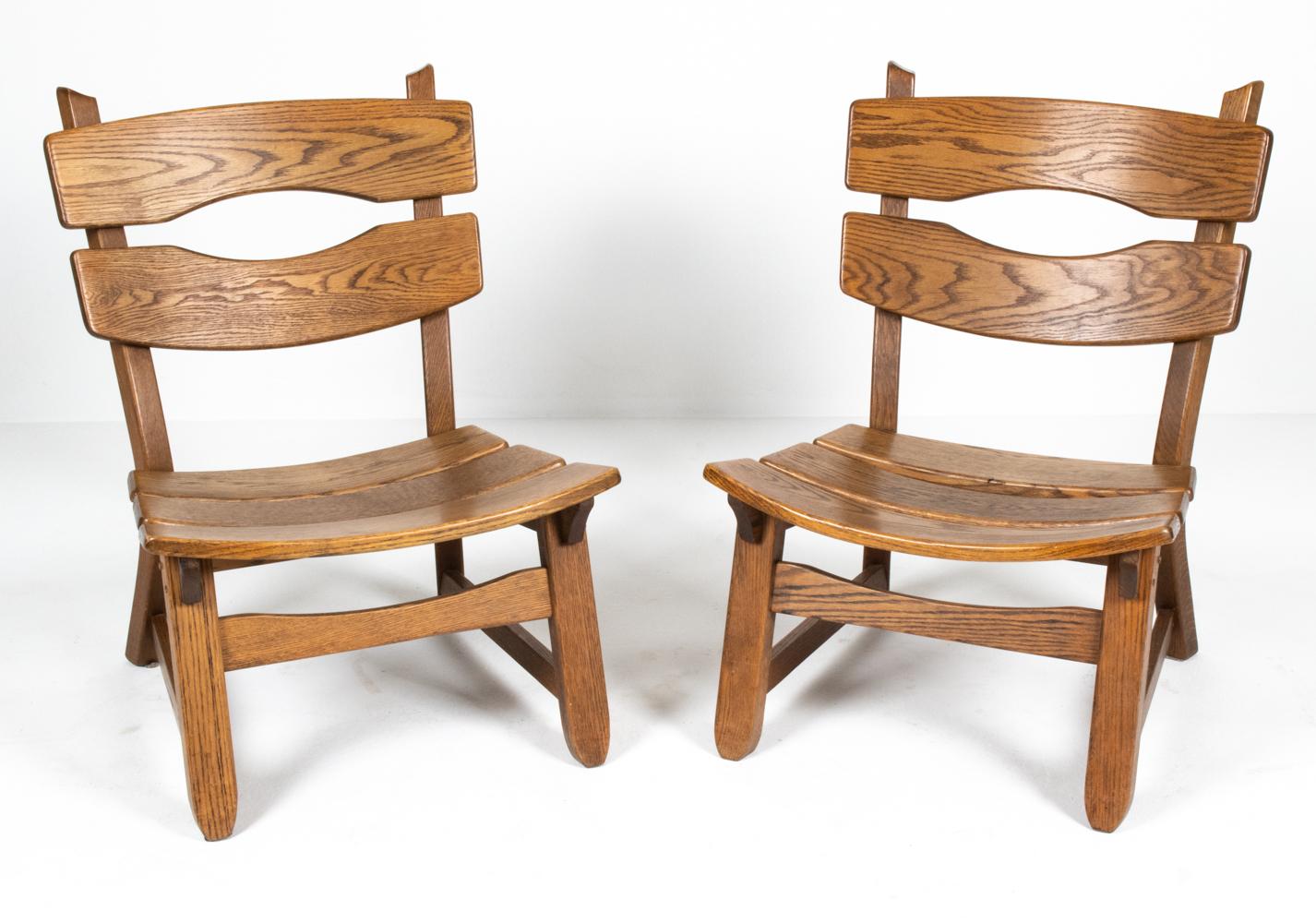 Pair of Brutalist solid oak lounge chairs by Dittmann & Co for AWA Radbound, Netherlands, c. 1970's. These substantial armless lounge chairs feature all wood construction in a dark stained oak with curved and rounded sculptural slatted seat and