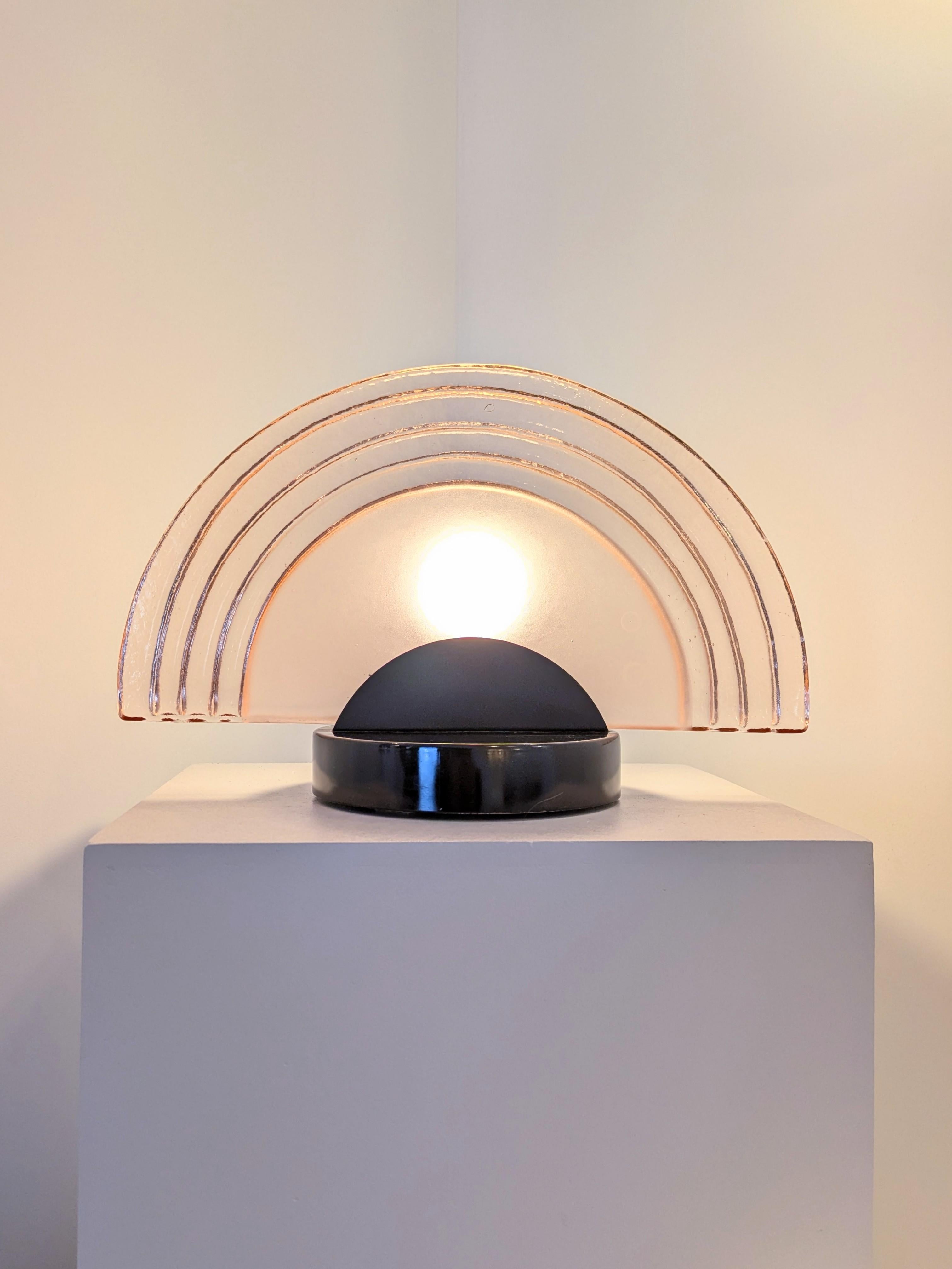 Pair of two table lamps model Diva made by Artemide and designed by Ezio Didone in the 1980's.
It appears that the glass would be just a part od the original lighting and the base has been produced to turn the original sconce into table lamp. 
The