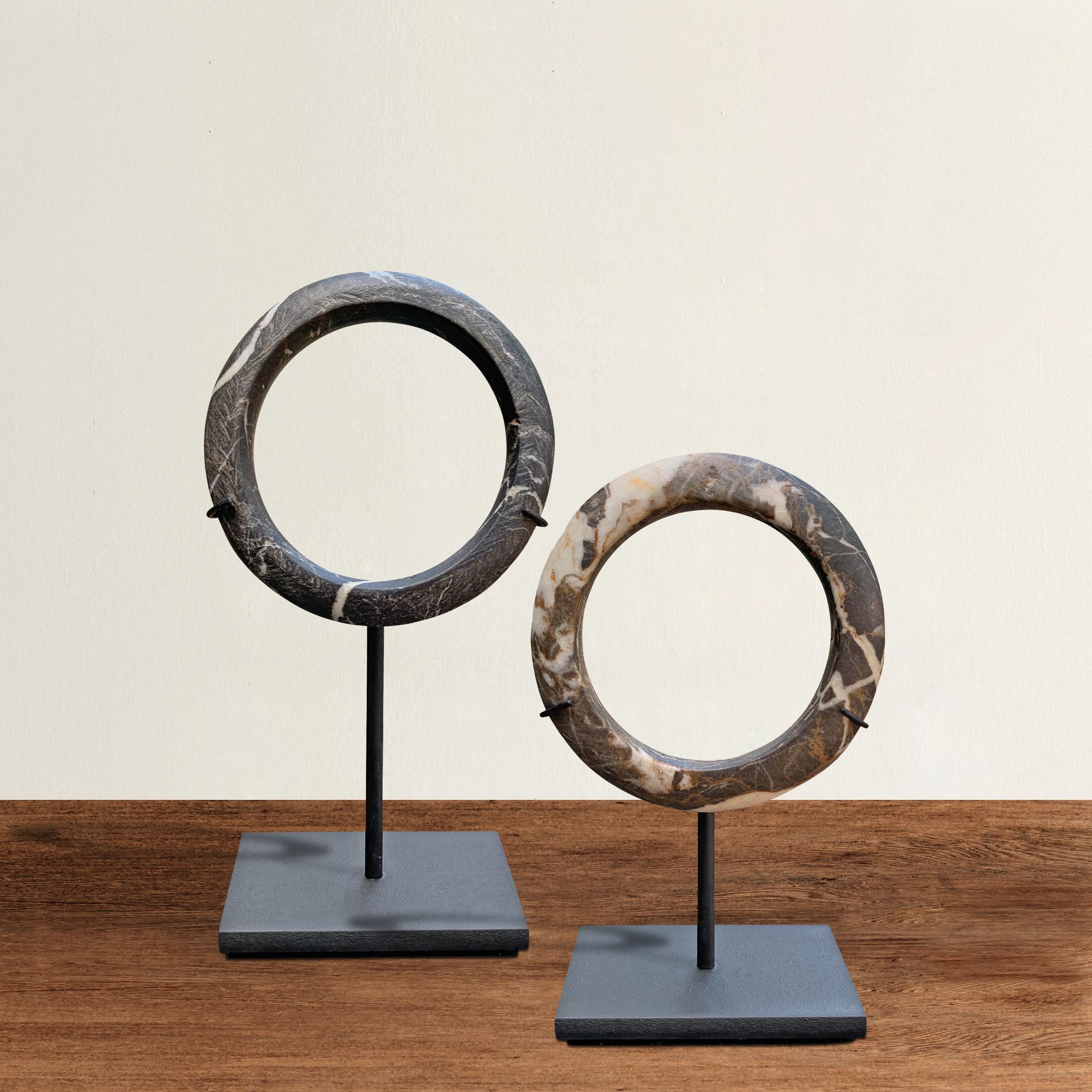 A pair of prehistoric, Neolithic Period, Dogon carved stone bracelets with heavy quarts veins running throughout, and mounted on custom steel stands. Some argue that these were used as forms of currency, while other scholars maintain that they were