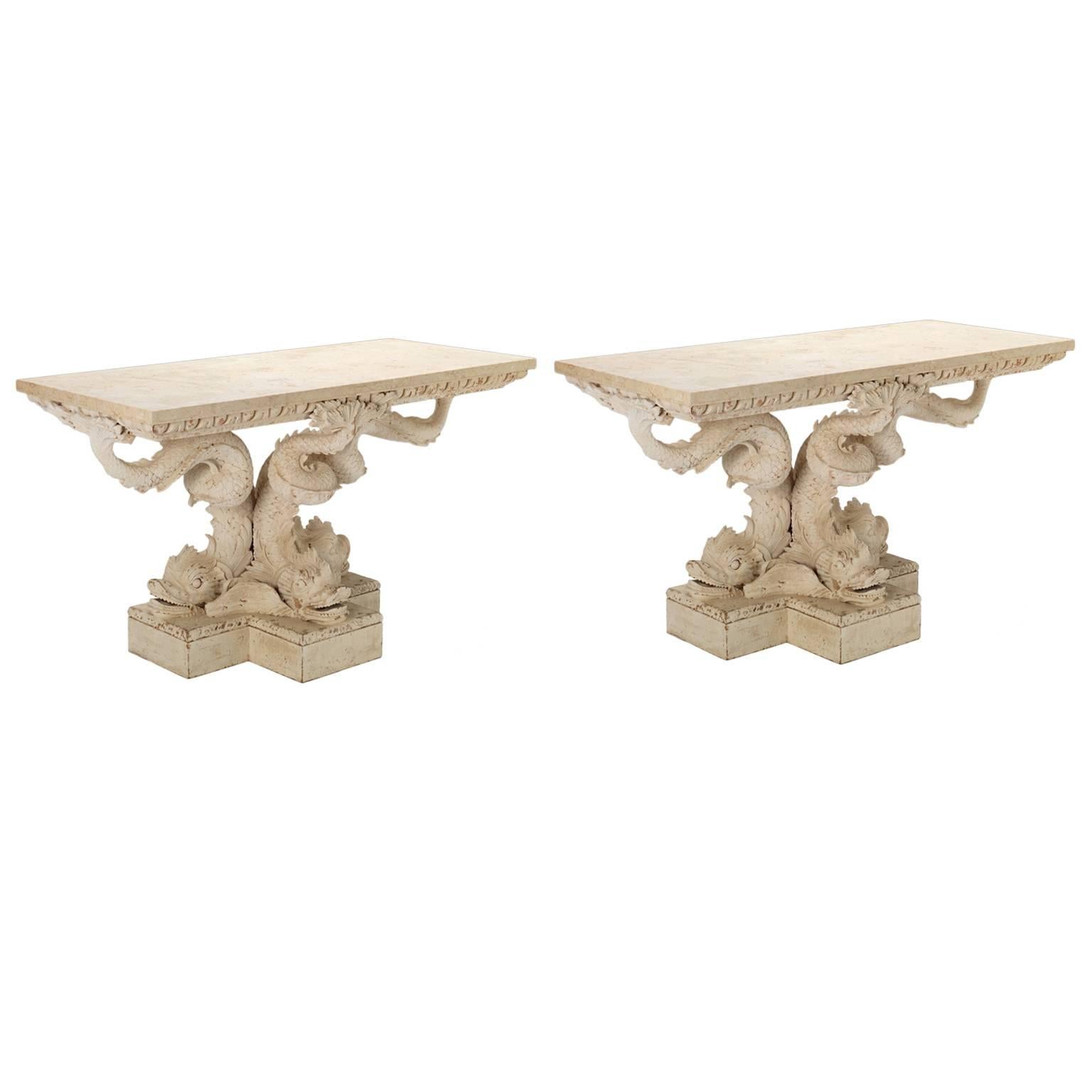 A Fine pair of dolphin console tables designed in the style of William Kent, the marble tops resting upon an egg-and-dart frieze supported by a trio of stylized Kentian dolphins resting upon carved step work plinths.

This item is made to order.

We