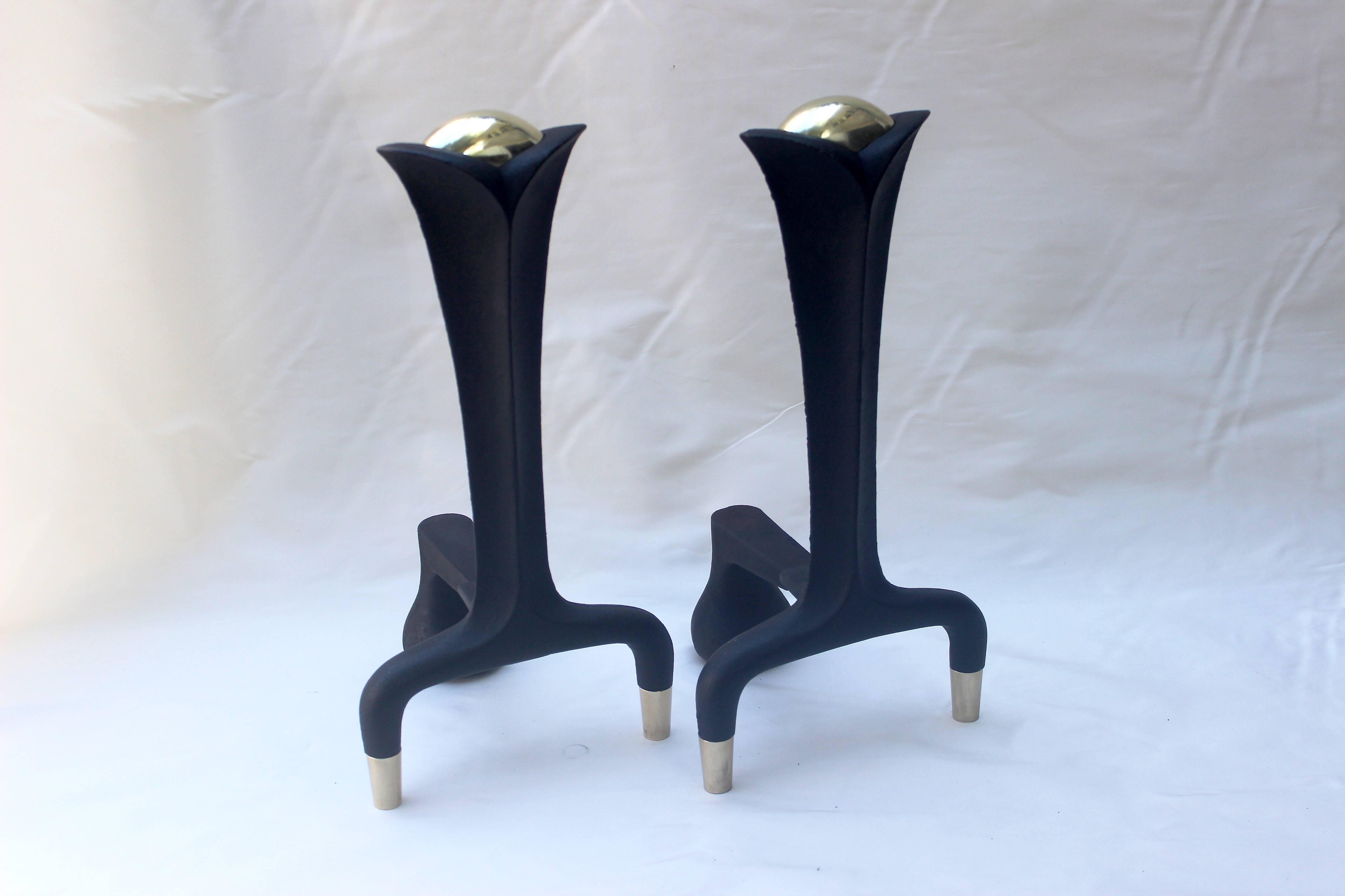 Pair of Donald Deskey andirons made of cast iron and brass.