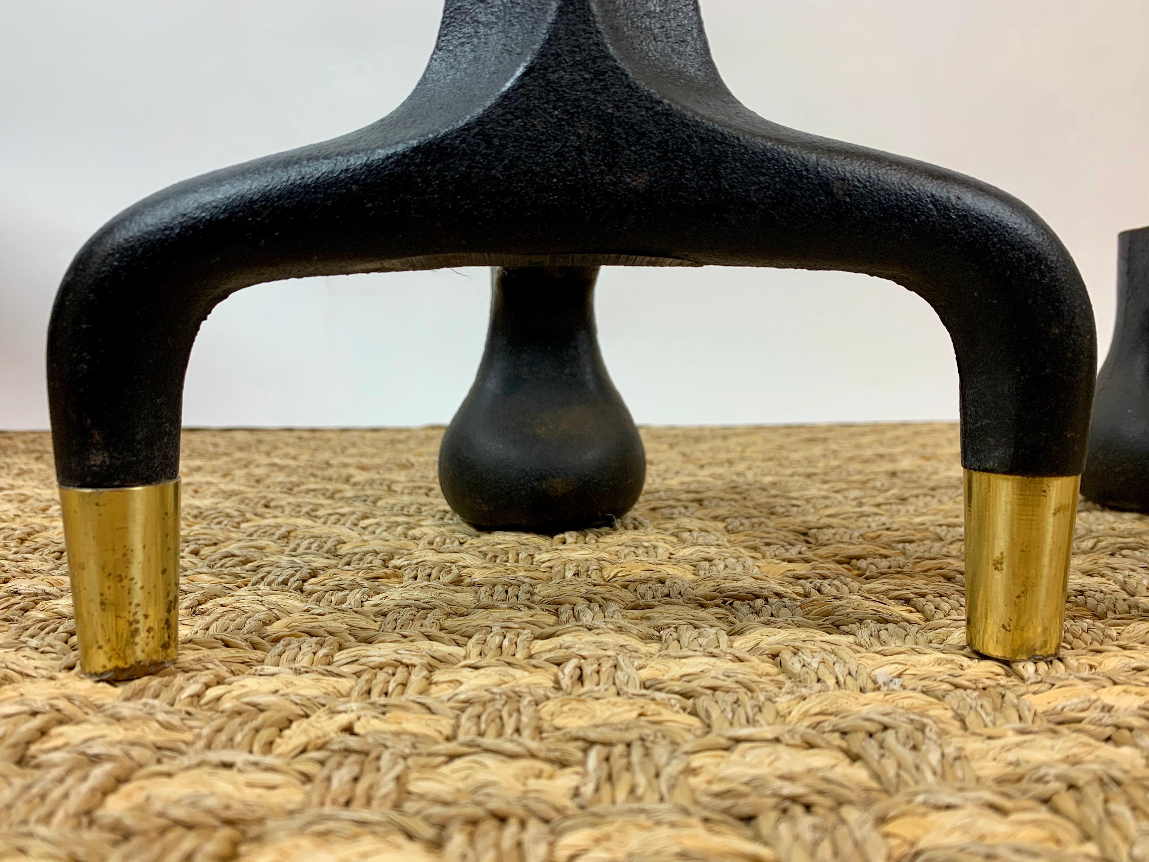 Coppia di candelabri moderni della metà del secolo attribuiti a Donald Deskey (1894-1989), caratterizzati da un'audace forma architettonica realizzata in ghisa con eleganti terminali a sfera in ottone e piedi con tappo in ottone. L'elegante colonna