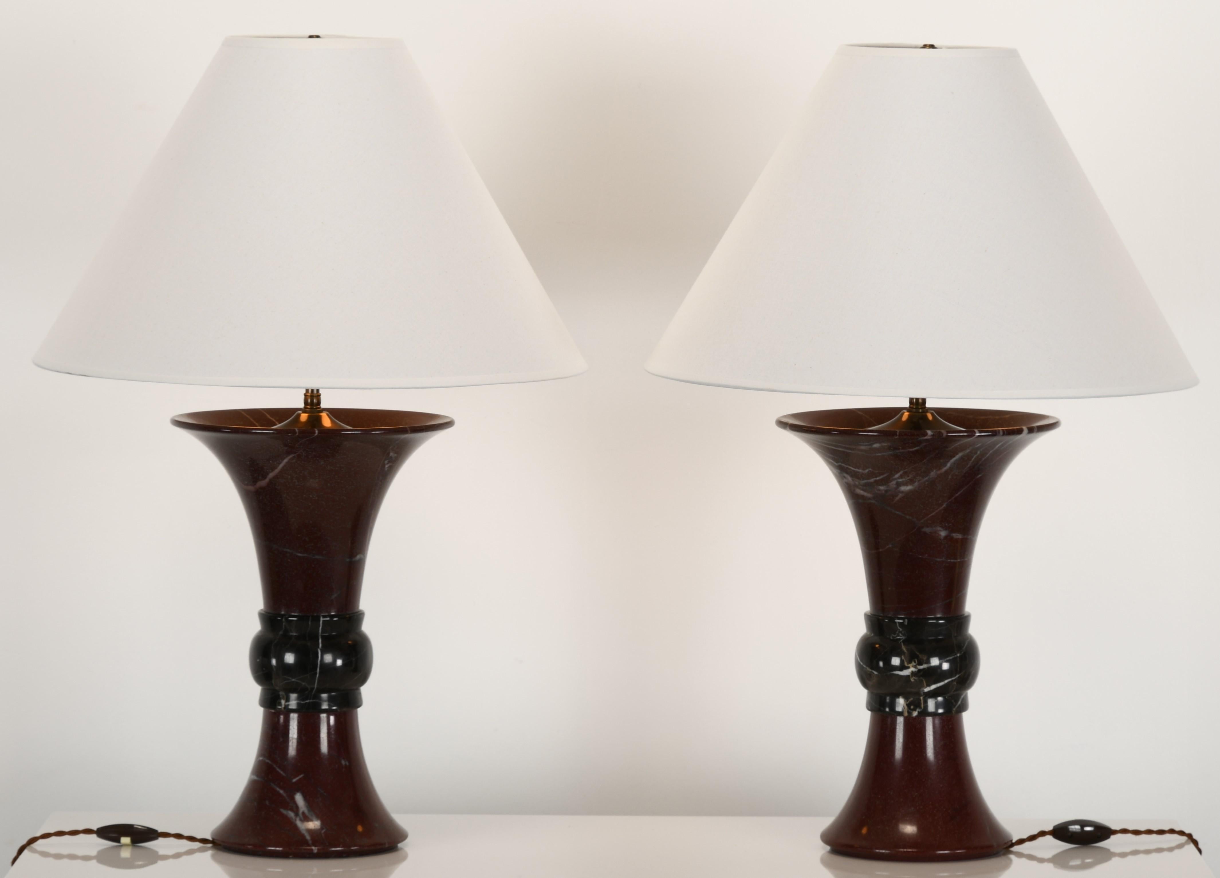A pair of Donghia marble two-tone Griotte red marble with white veining mixed with Belgian black and white marble center table lamps. Shades not included. Lamps are in very good condition labeled 