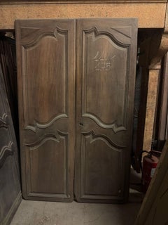 Pair of doors with wavy panels carved in walnut, Italy