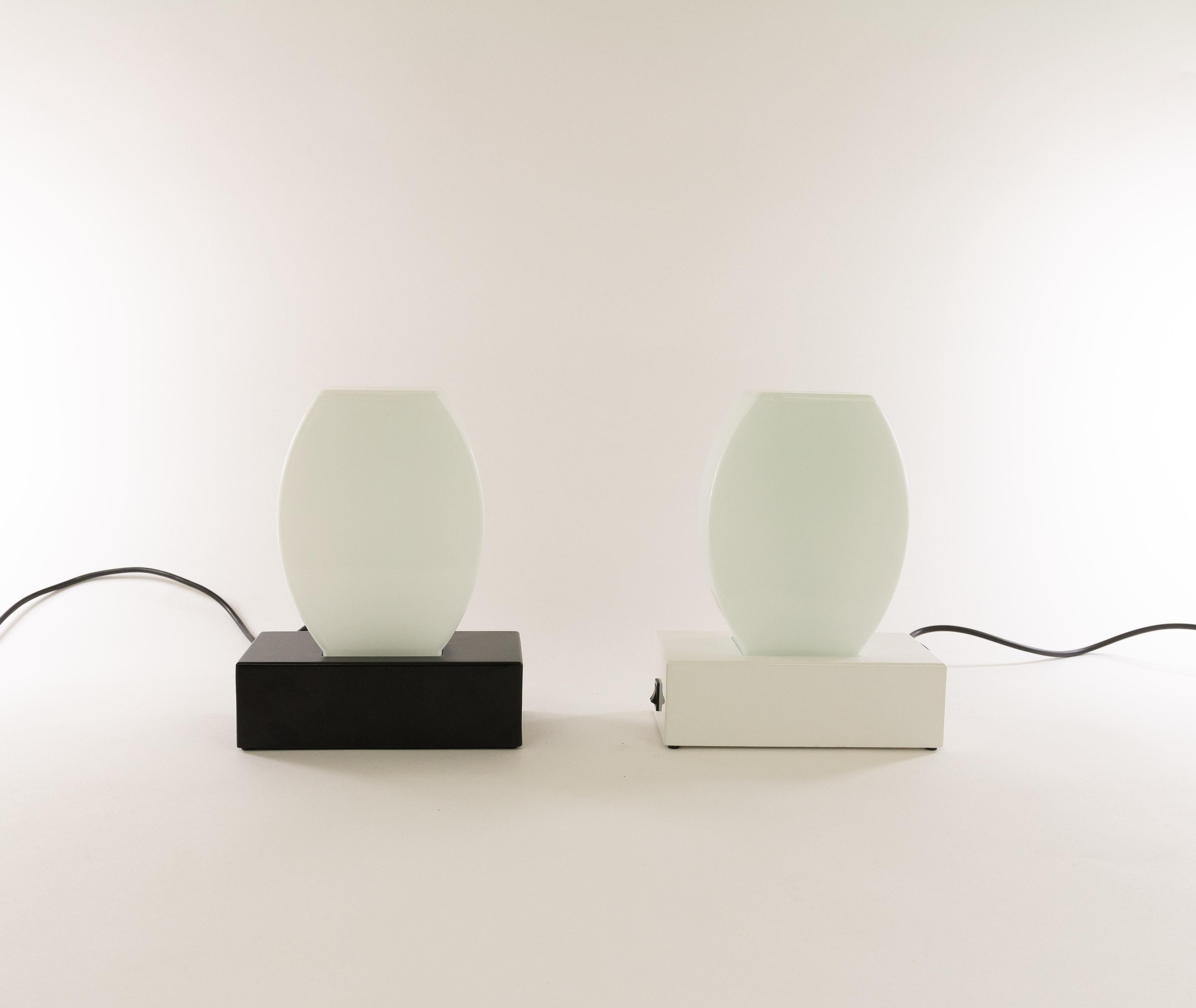 Pair of Dorane table lamps designed in 1977 by Ettore Sottsass and manufactured by Stilnovo, Milan.

The base of these lamps is made of lacquered metal (one in white and the other one in black). The shade is made of Murano glass. It has the