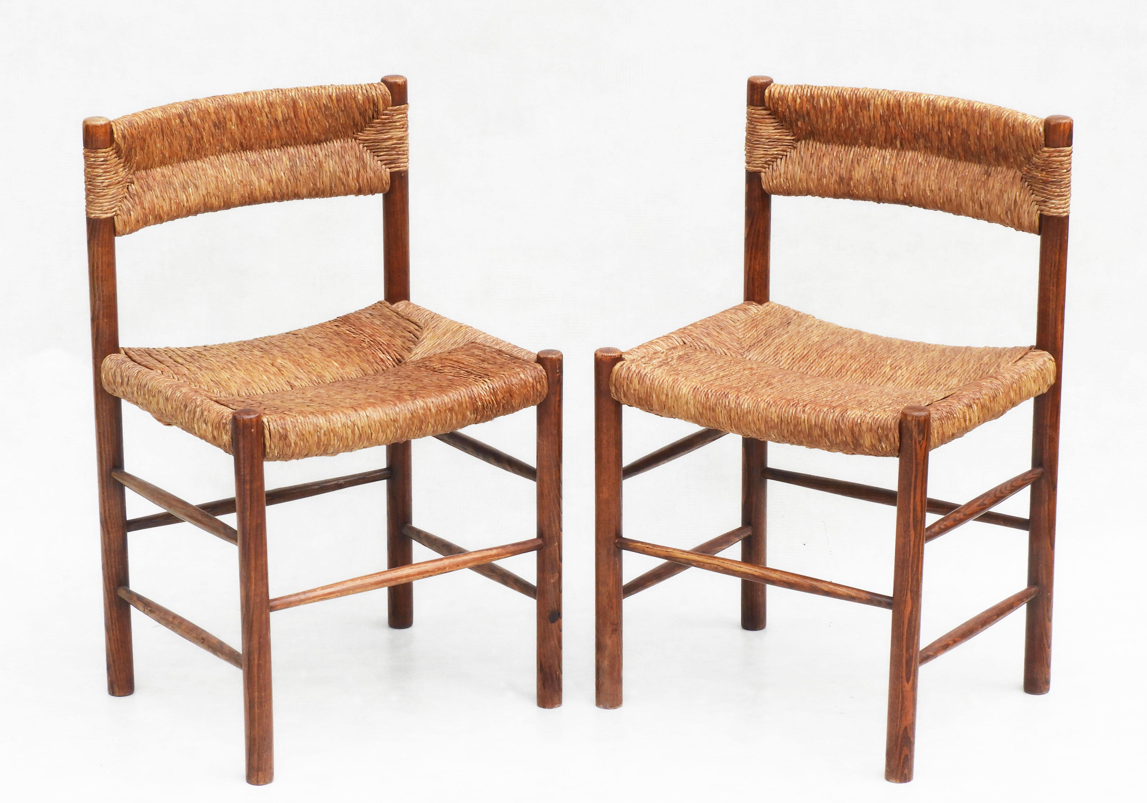 A good pair of Charlotte Perriande “Dordogne” dining chairs from French furniture maker Sentou c1960. 

Woven rush seat and backrest on a warm brown wooden frame. 

A stylish mid-century modern take on a traditional rustic design. 

In good