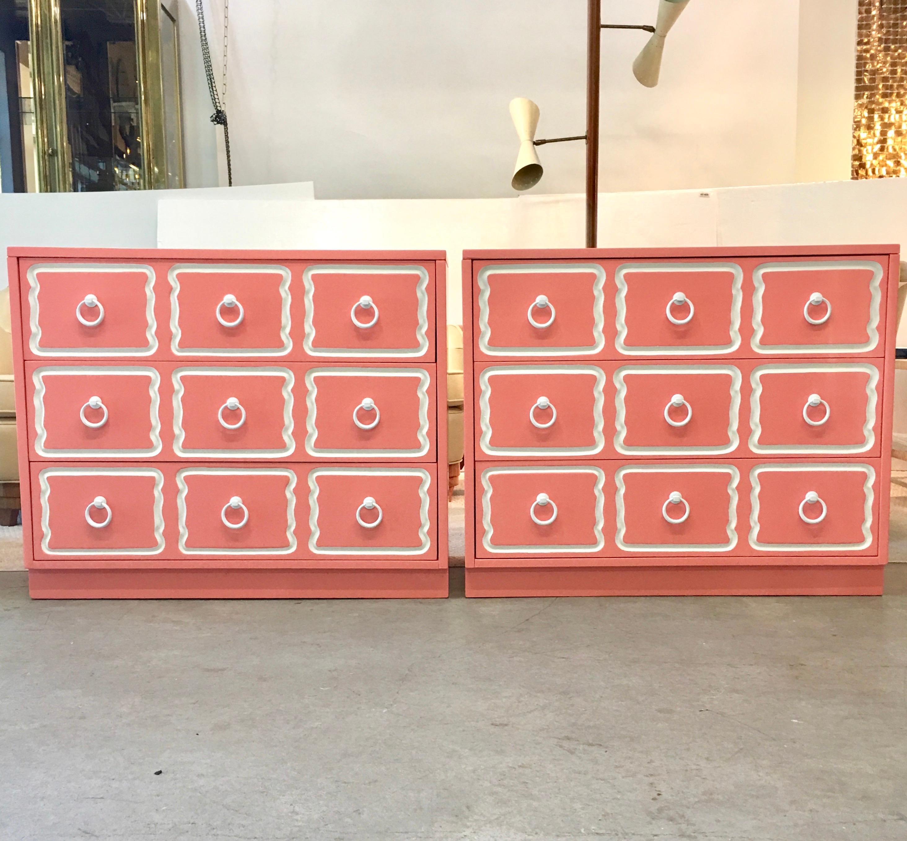 Pair of vintage Dorothy Draper style España bunching chests of three drawers which we have newly refinished in Lyford Cay pink, white trim and white powder coated original ring pulls. These are total sunshine on a rainy day. Great color: soft pink