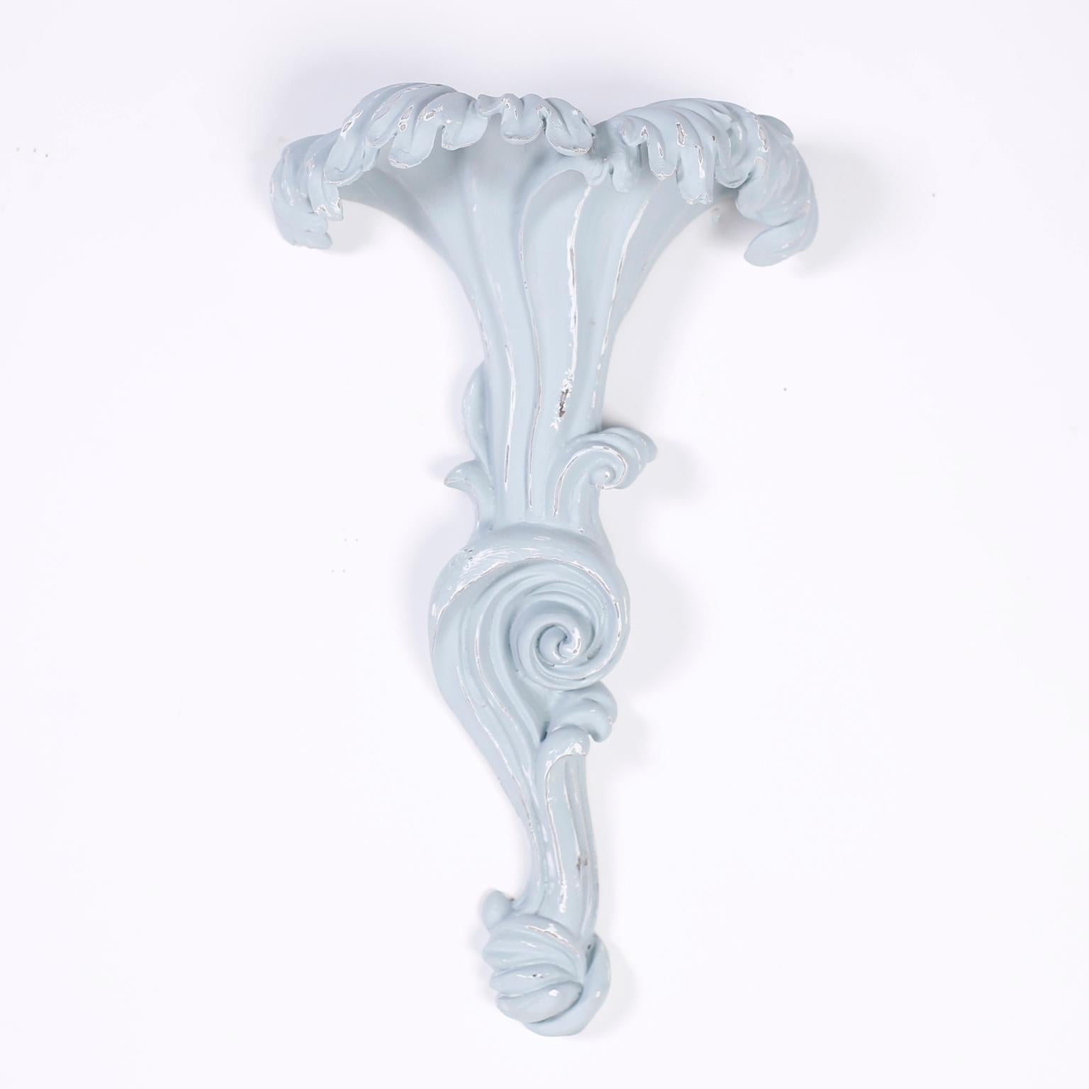 Exciting pair of decorative wall brackets crafted in Roche style composition having contrived aged blue grey paint.