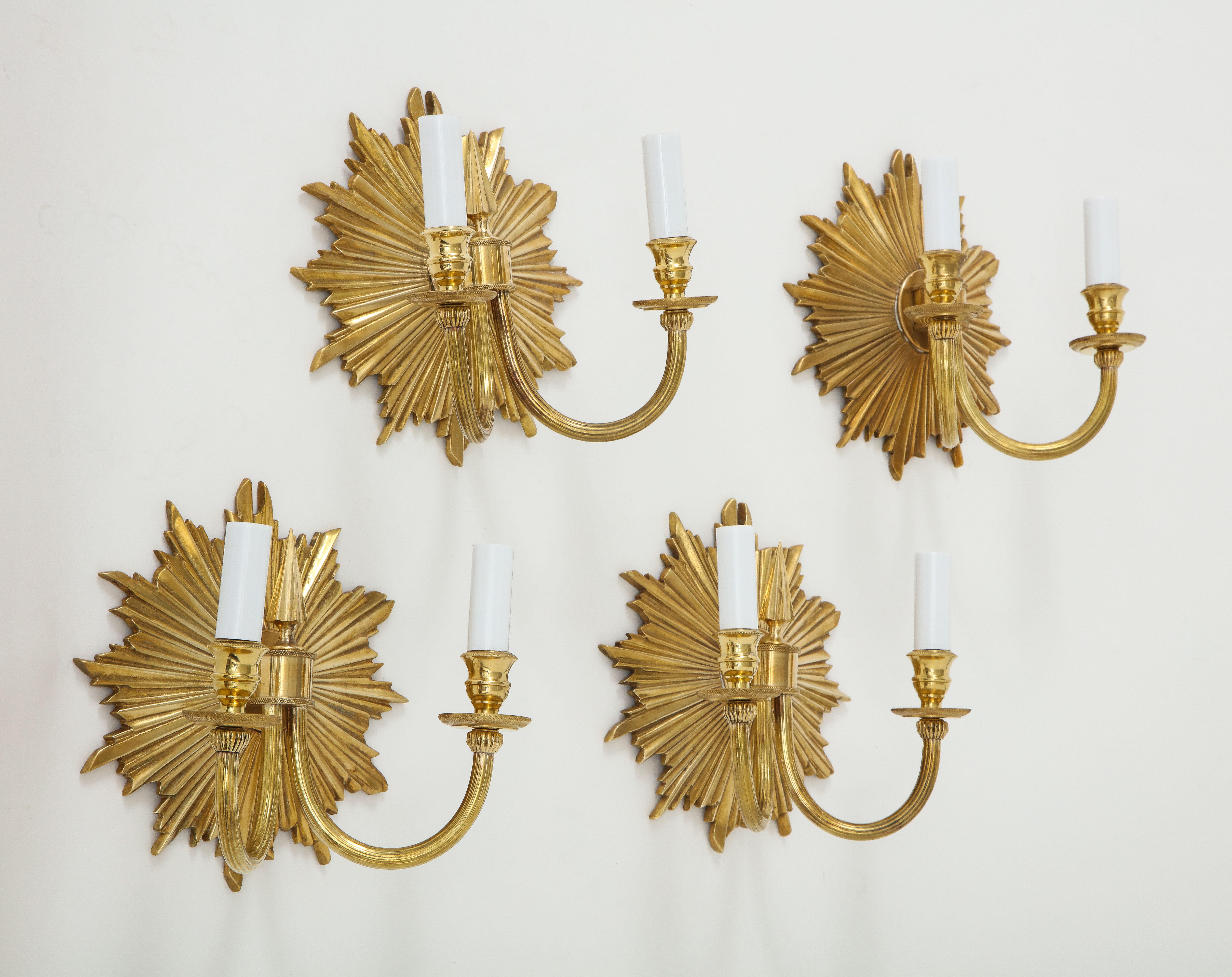 A set of four brass double-arm sconces with a lovely sunburst black plate and beautiful detailing throughout, including fluted arms and delicate beading on the bobeches (base supporting the lights). We have two pairs of these beauties they would be