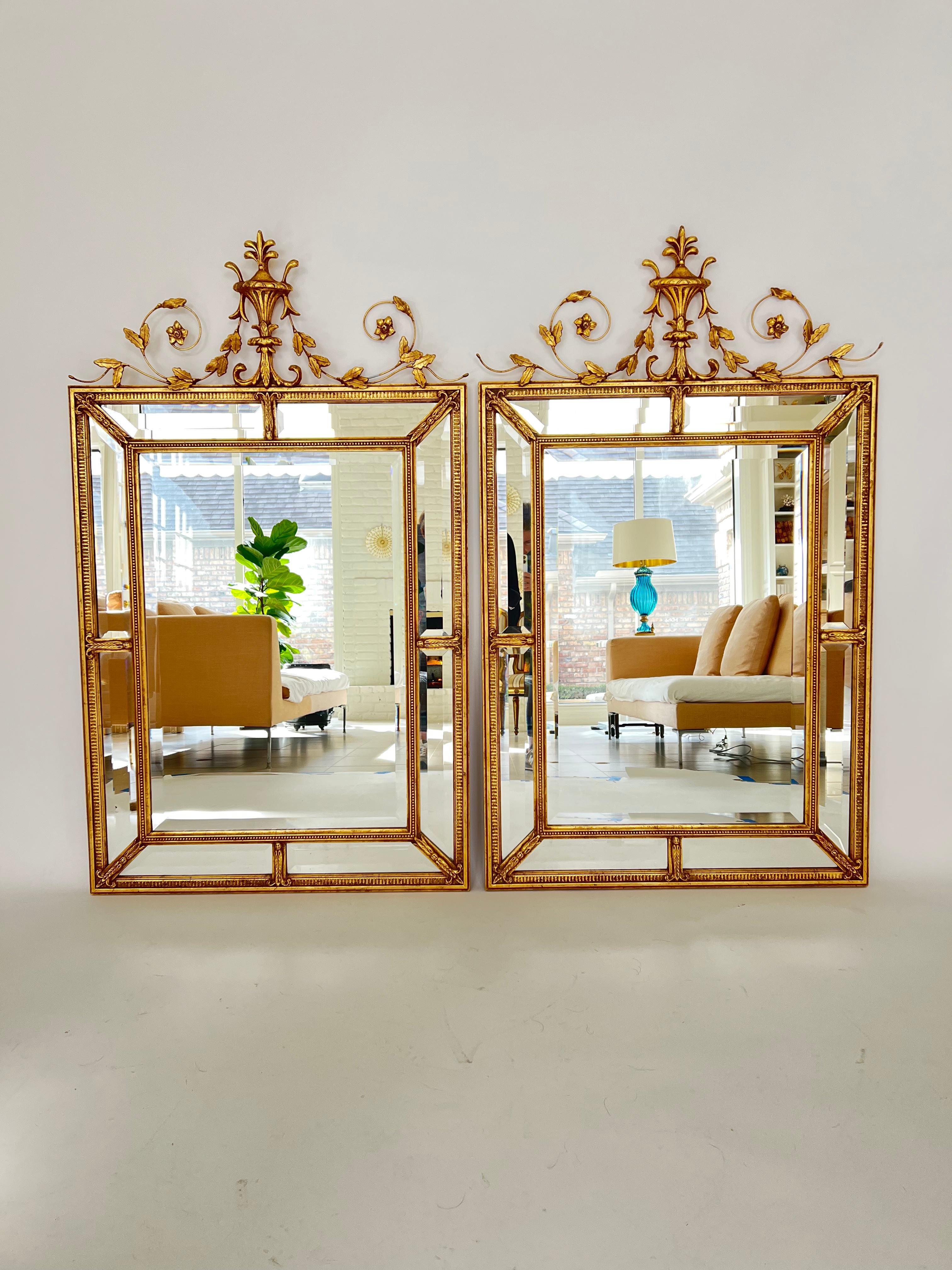 Pair of double bordered gilt frame mirrors with crest of urn and flowered scrolls. This high quality pair is made of beveled glass in the English Style with an 18th century design. Hand gilded by Friedman Brothers. Very good condition.