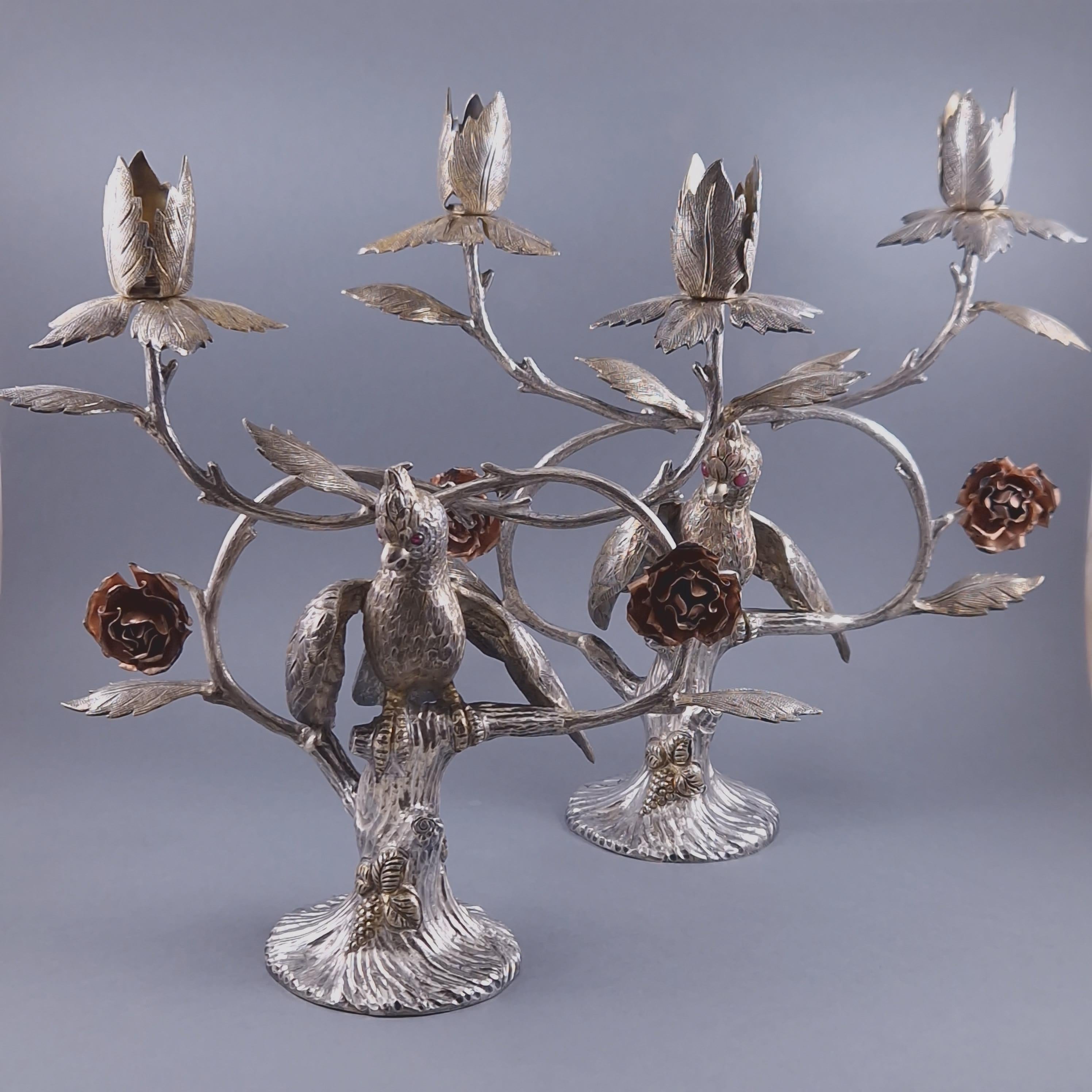 Pair of double candlesticks in sterling silver and gilt 

Decorated with flowers, foliage and a bird resting on a tree 

Hallmarked Sterling Silver and 925 
By Tané

Measures: Height: 27.5 cm 
Length: 26 cm 
Weight: 3125 grams.