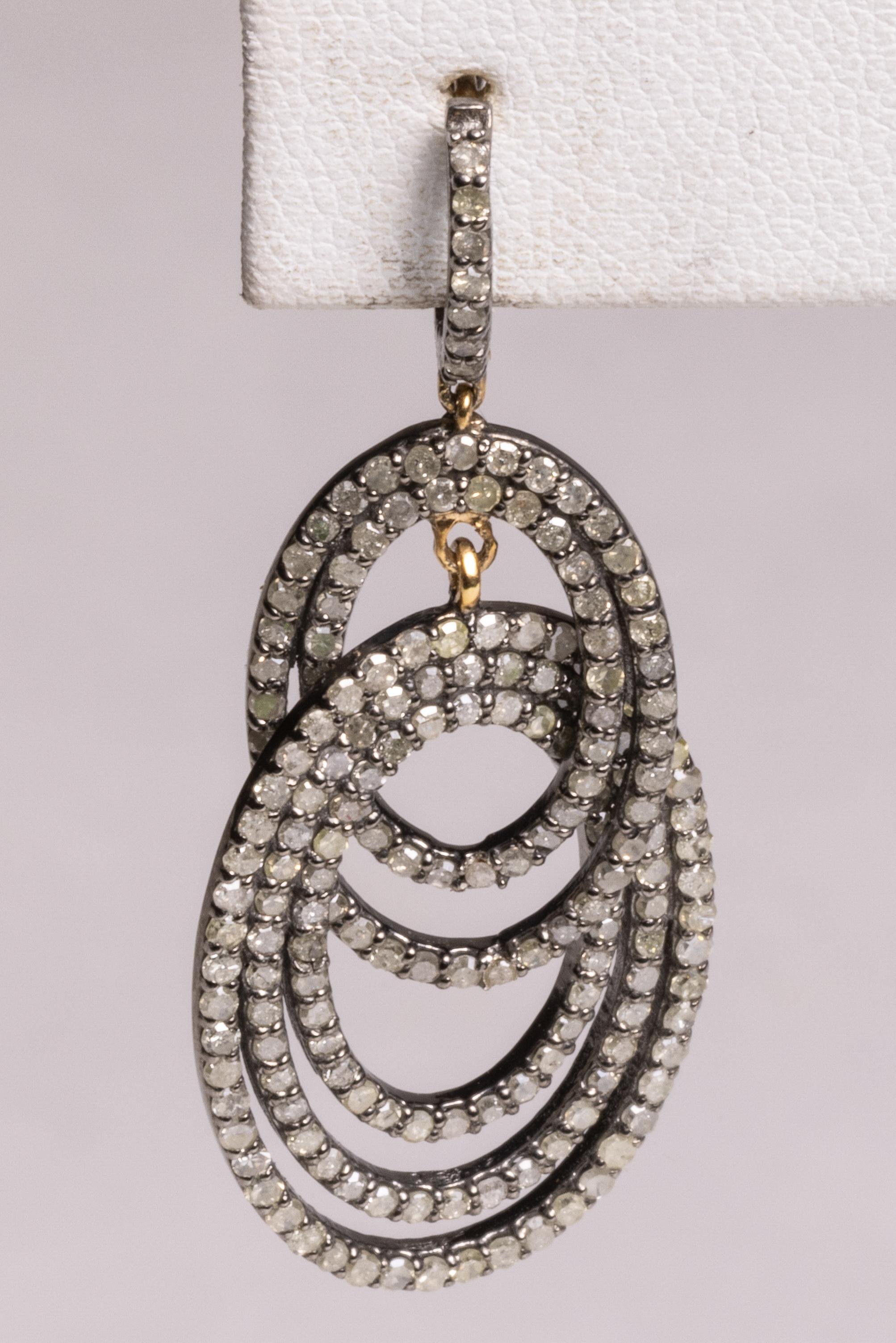 A pair of double loop drop earrings of pave` set, round brilliant cut diamonds.  The first loops features two bands and the second loop features three.  Set in sterling silver with an 18K gold post for pierced ears.  Diamonds total 4.81 carats.   