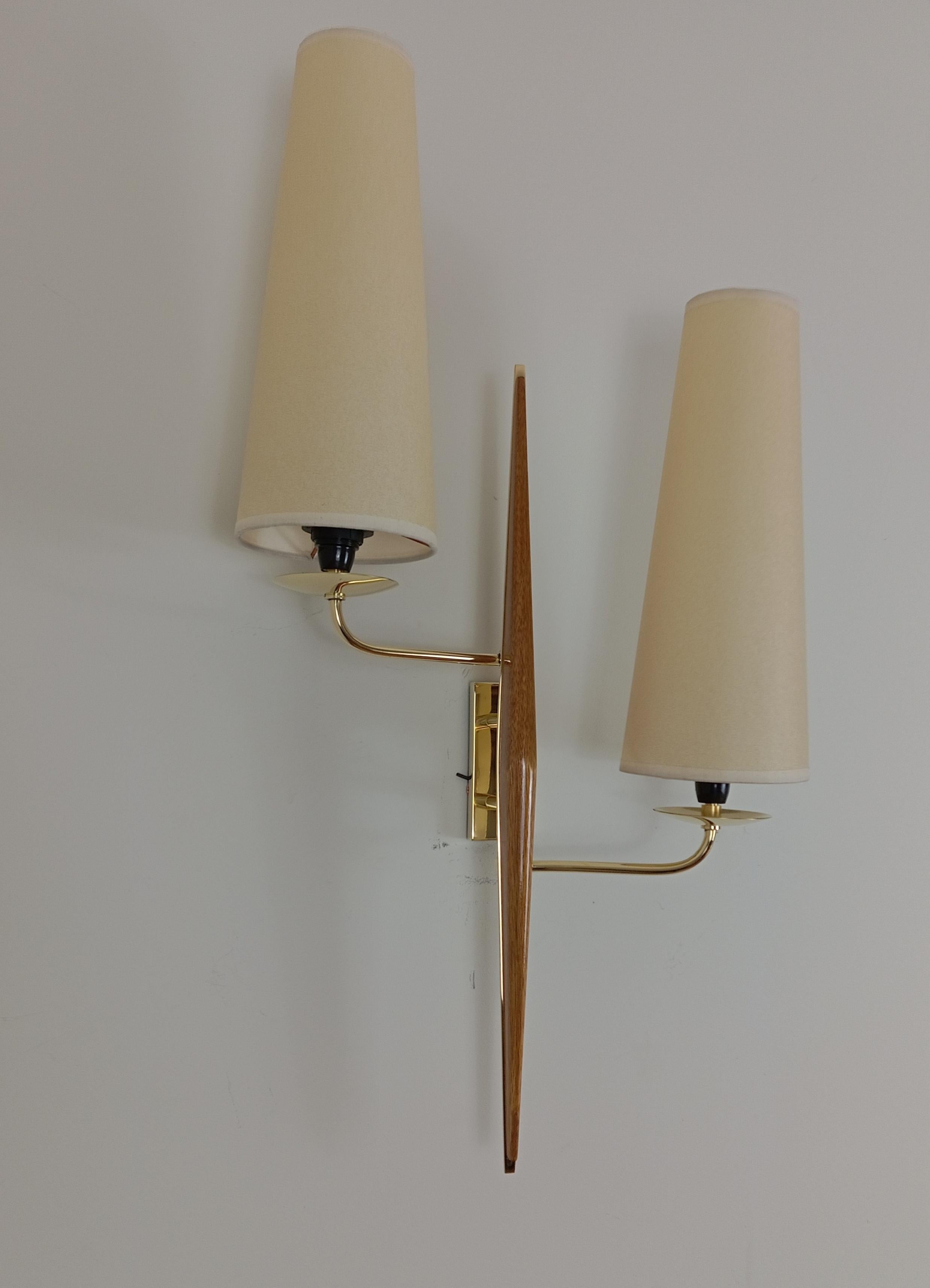 Pair of double wall lights in solid brass and varnished teak wood.
French work by Maison Lunel for Royal Lumière, circa 1950.
These sconces have been restored, new wiring to EU standards, lampshades redone to model, polished brass.
Perfect