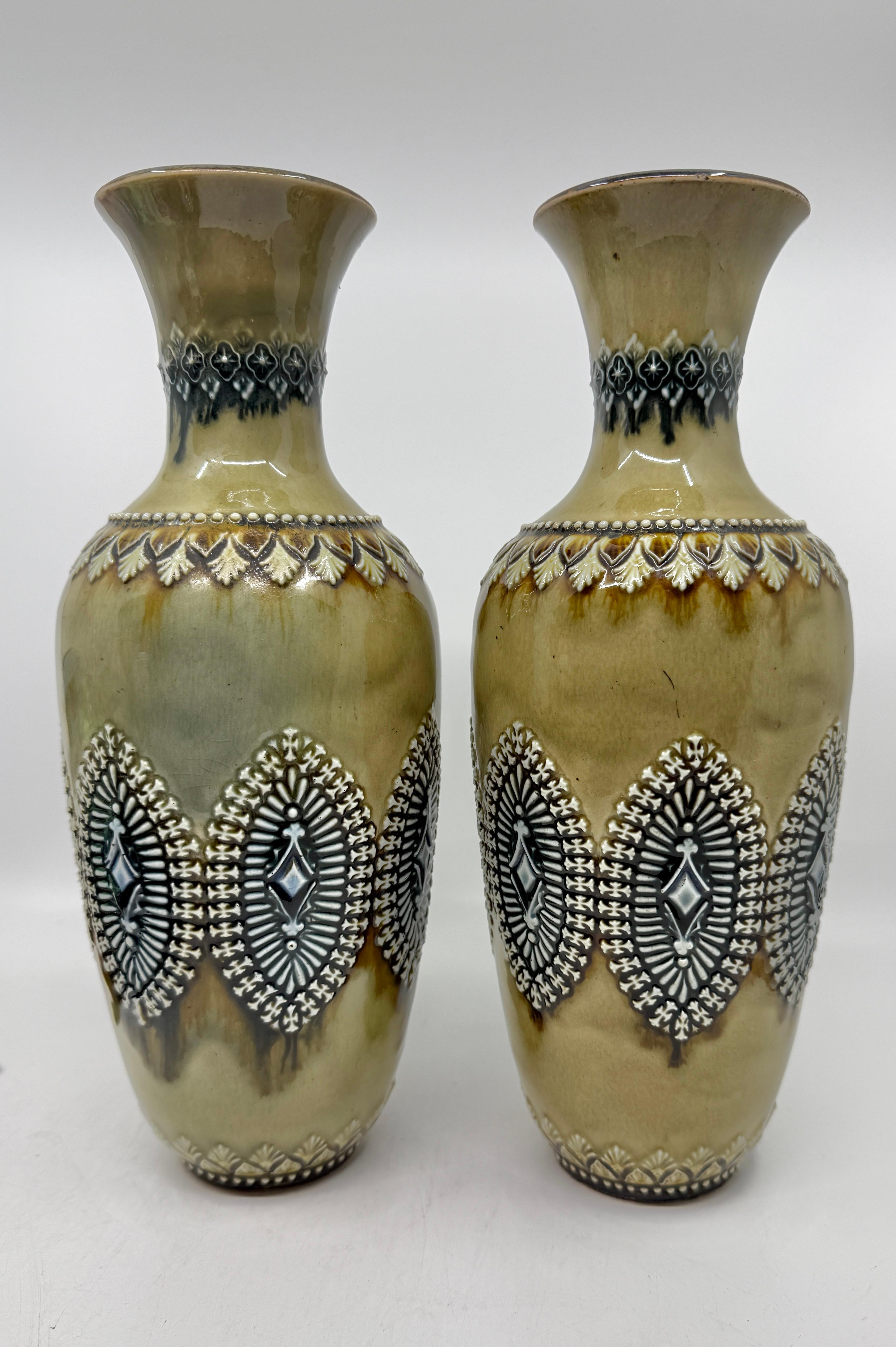 A nice pair of Doulton Lambeth Salt Glazed Stoneware vases with incised and applied decoration. There are both signed on the bases. They are dated 1884. They are monogrammed with a decorators marks but I’m unfamiliar with the makers marks. 
The