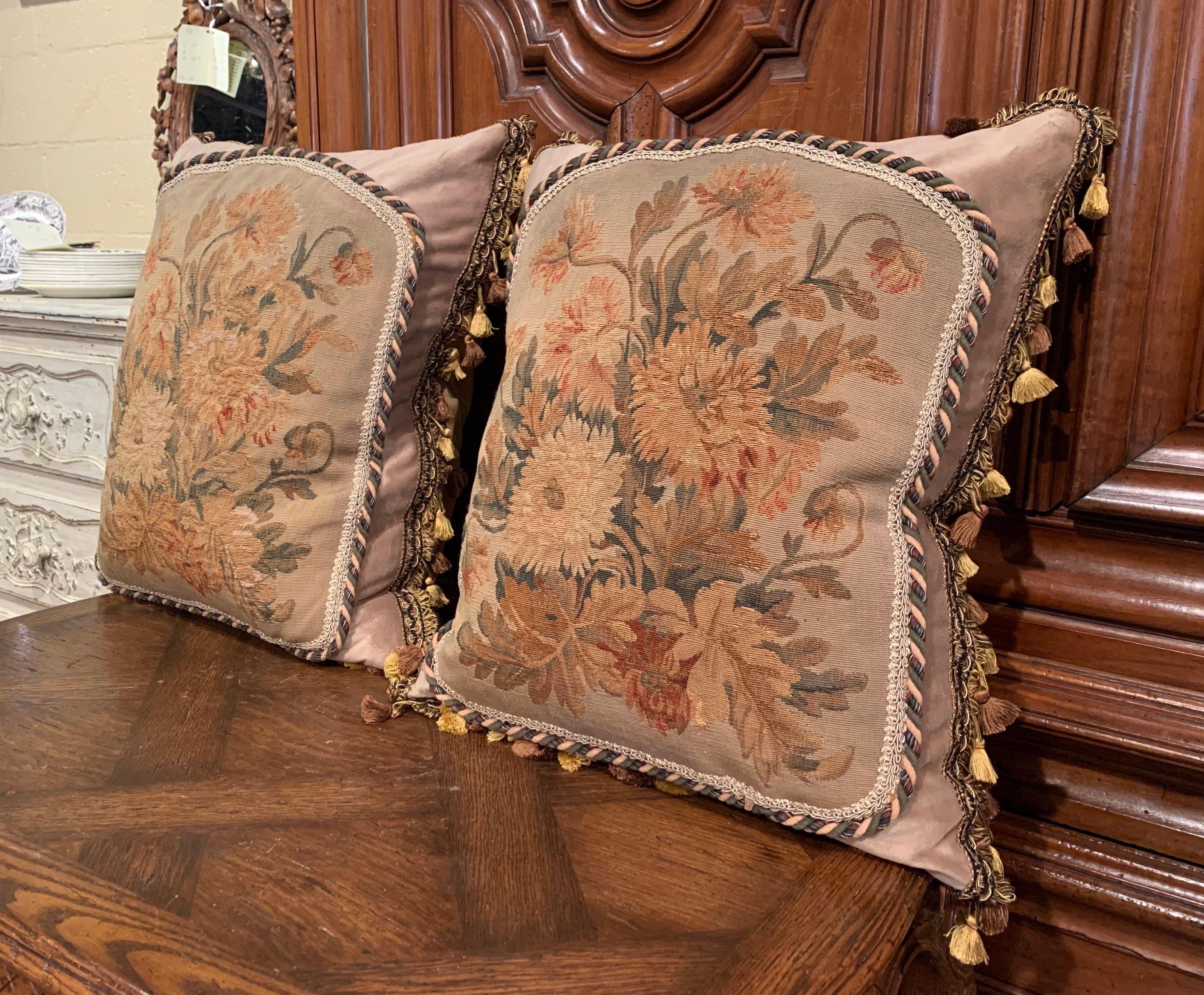 Decorate a sofa or a bed with this elegant pair of pillows; made with antique floral tapestry from Aubusson, France, each pillow is handmade with complimentary trim and tassels, embellished with silk and velvet fabric. The pillows, filled with down,