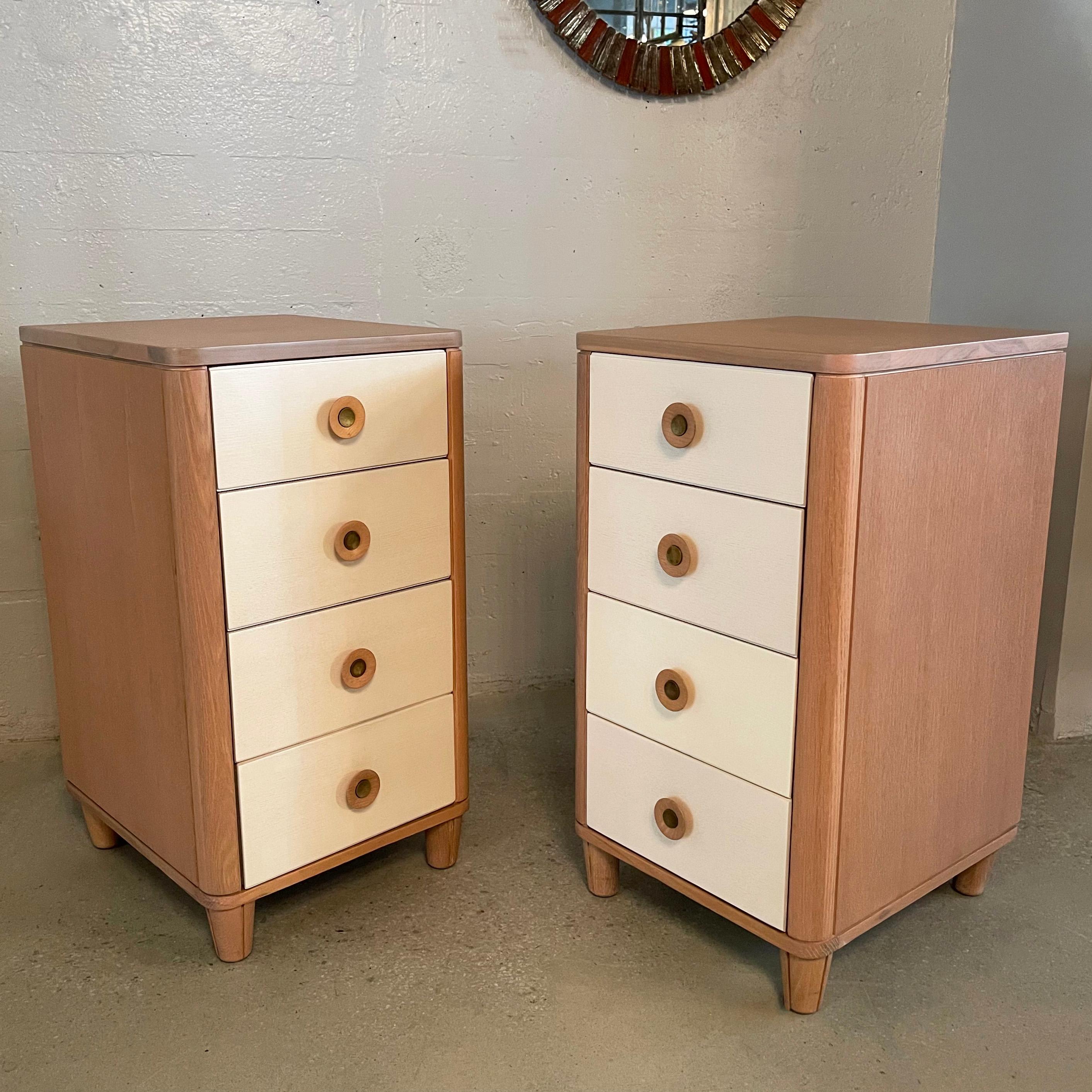 Pair of slim, highboy, 4 drawer pickled oak dressers by Raymond Loewy for Mengel feature a two-tone finish in blush pink with cream drawers. The drawers measure 14 W x 16 D x 6 H inches.